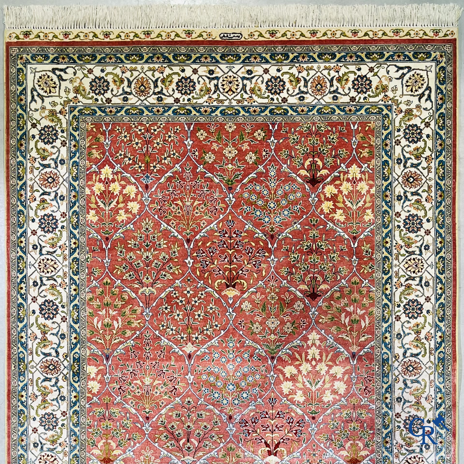 Tapis d'Orient: Un tapis finement noué à la main en laine et soie avec un décor floral.<br />
Signé.