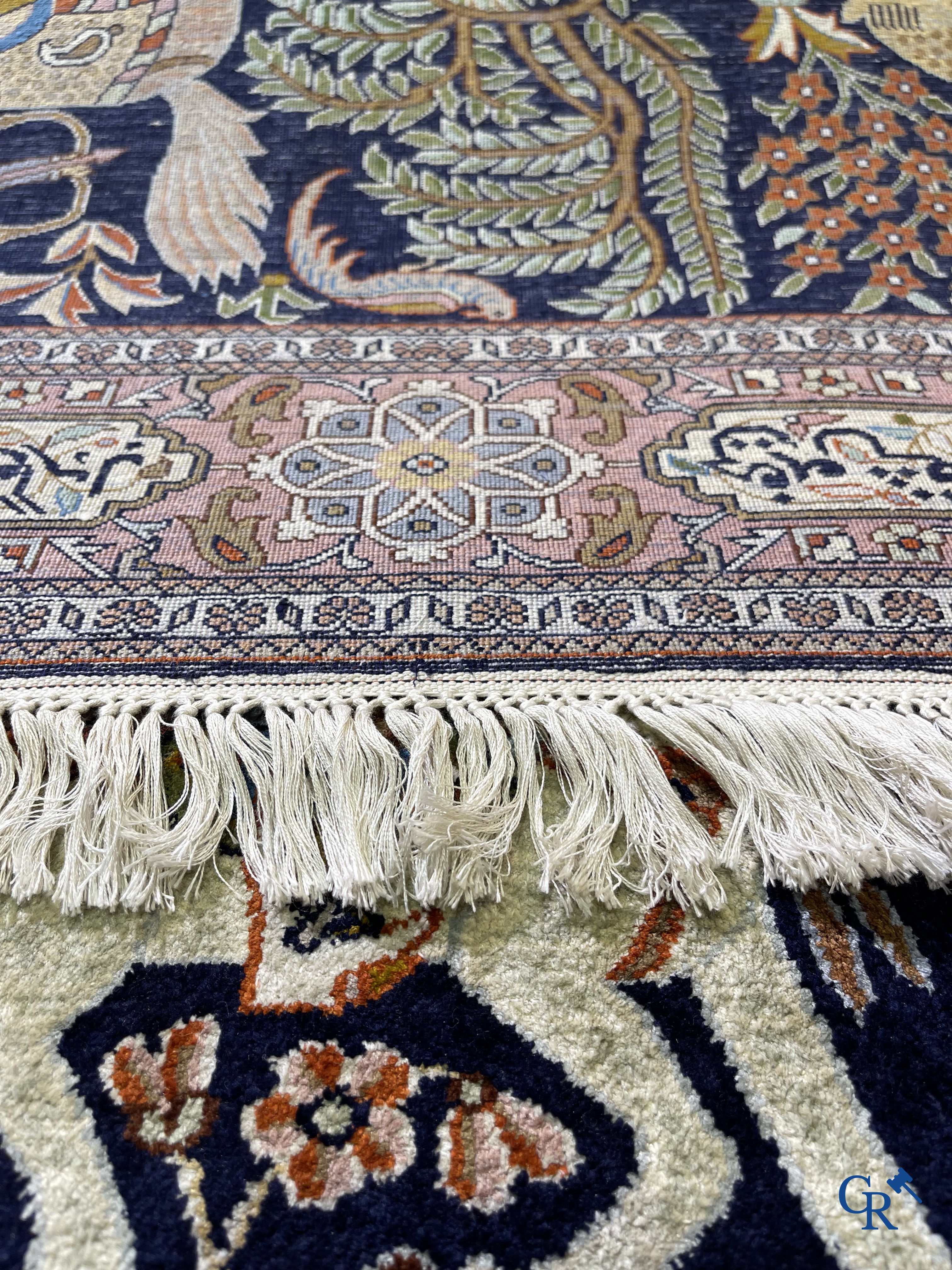 Oriental rugs. Iran. A finely hand-knotted Persian rug in wool and silk with hunters on horseback and inscriptions.