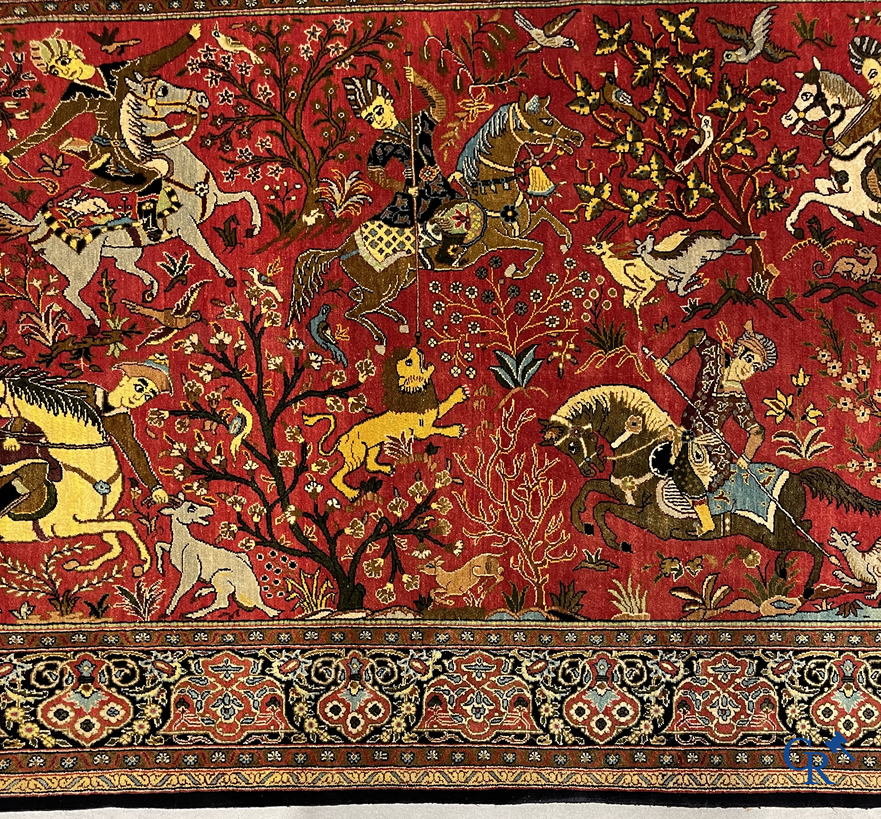 Oriental carpets, a Persian carpet in silk with a scene of hunters on horseback.