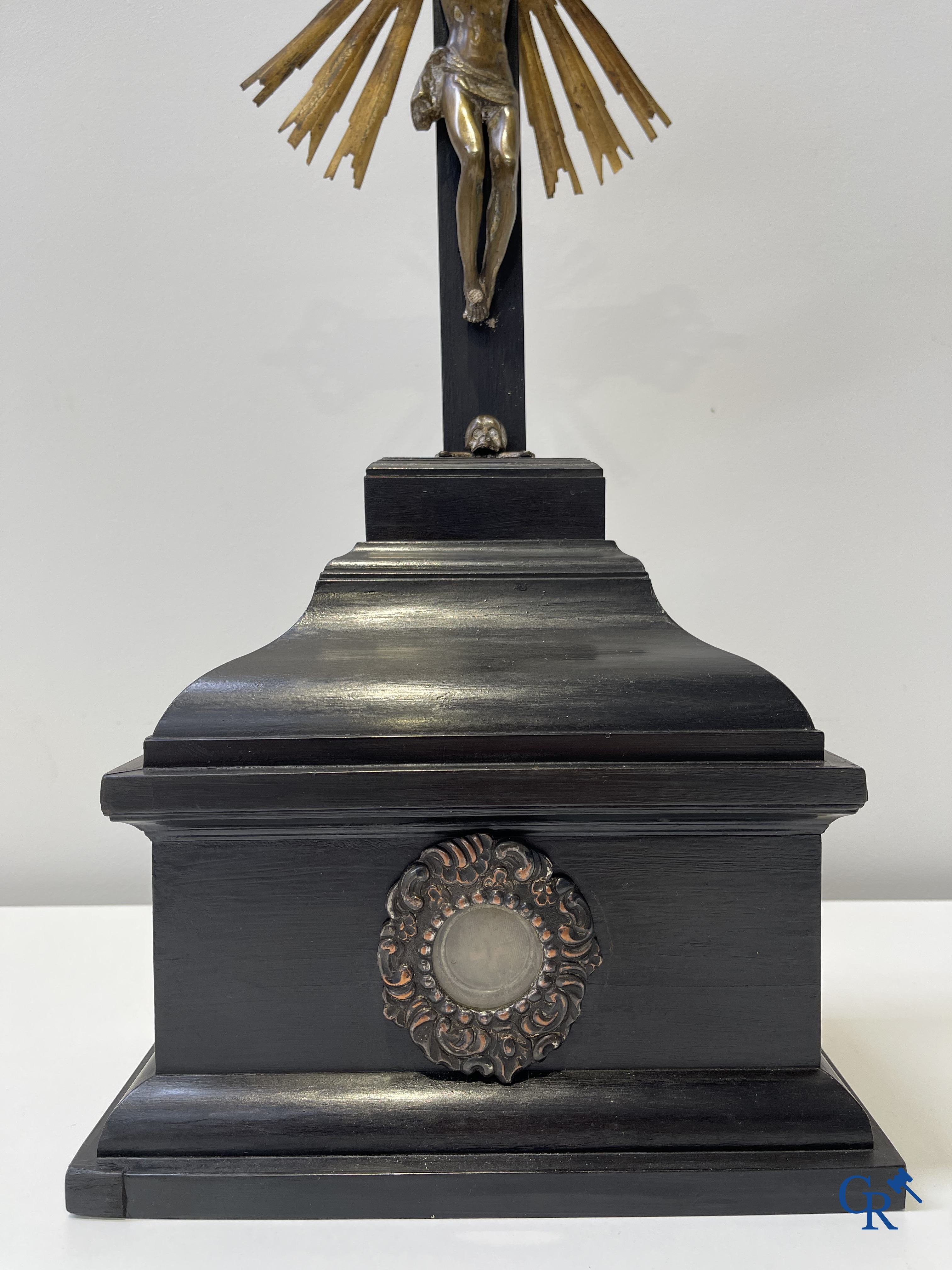 Religious objects: Bronze Christ on the cross held up by an ebony reliquary with relic.