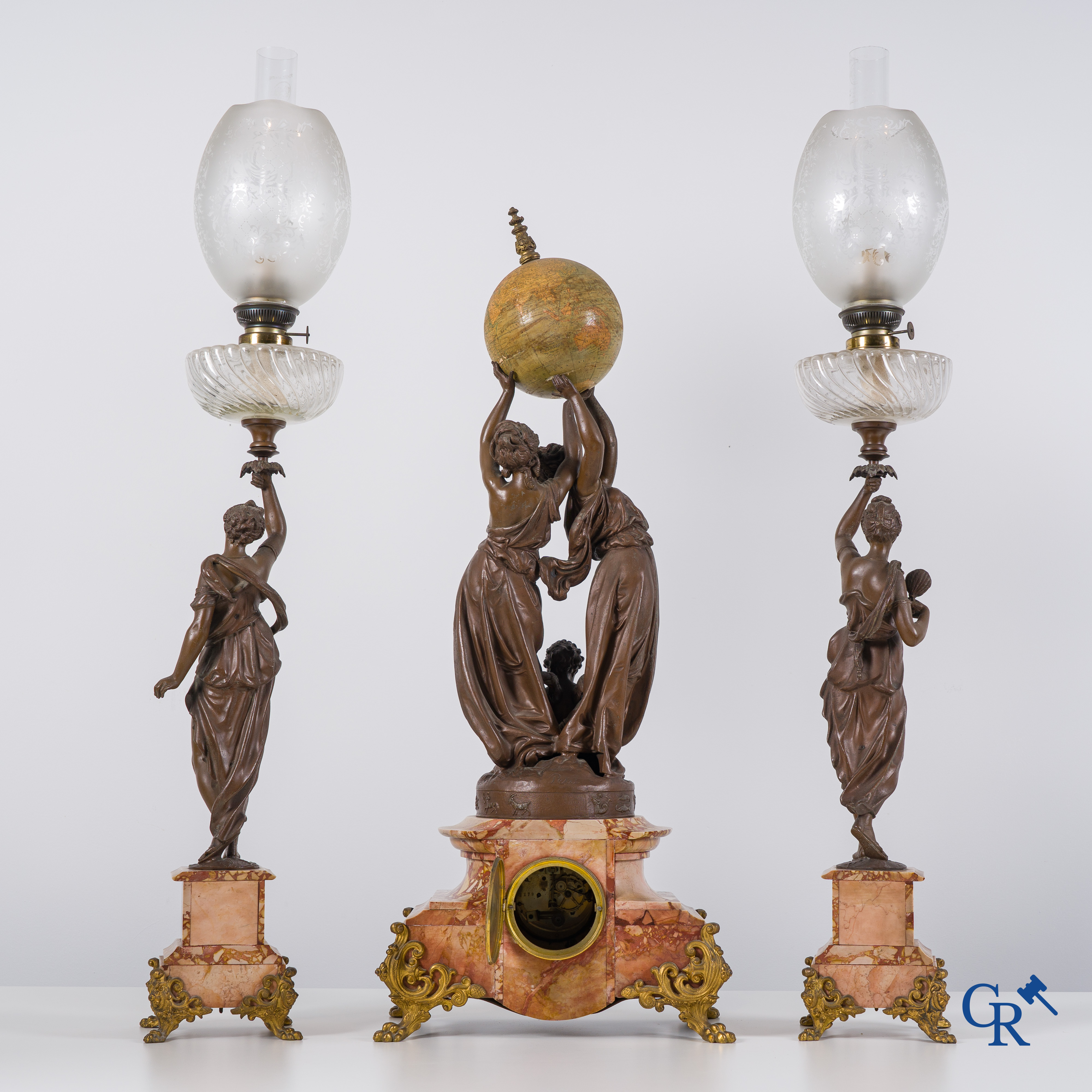 An imposing clock set in marble and spelter, signed Petit, petroleum lamps with glassware in the manner of Baccarat.