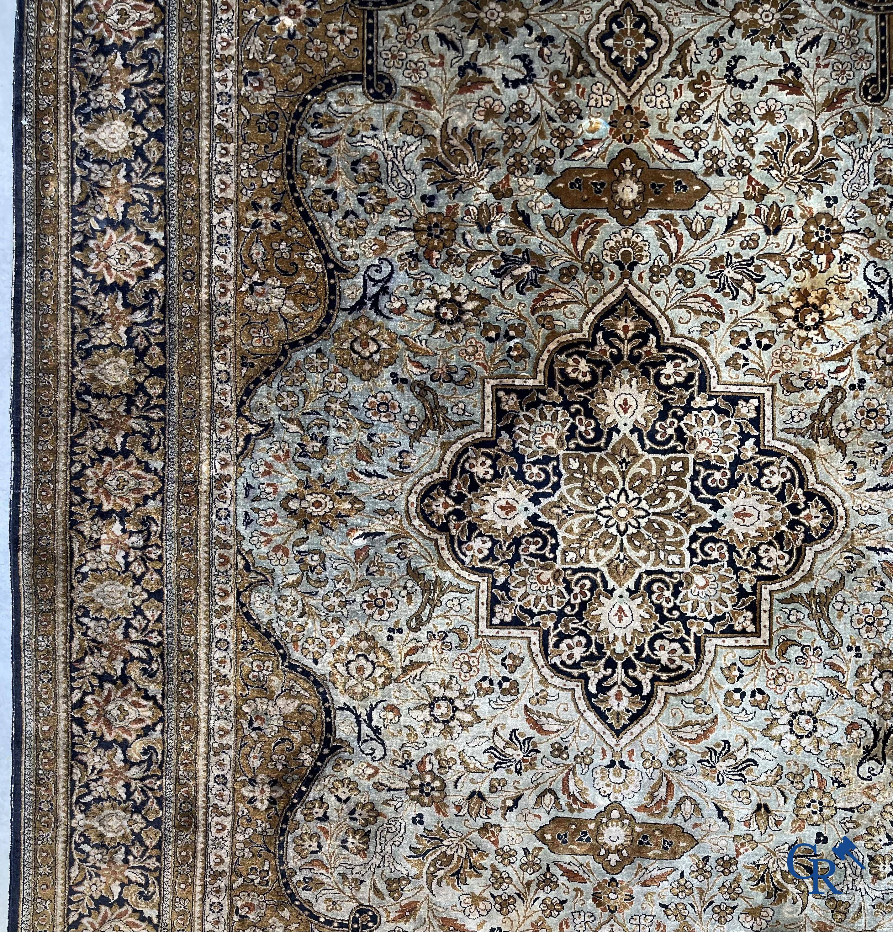 Tapis d'Orient. Un tapis en soie finement noué à la main avec un décor floral.