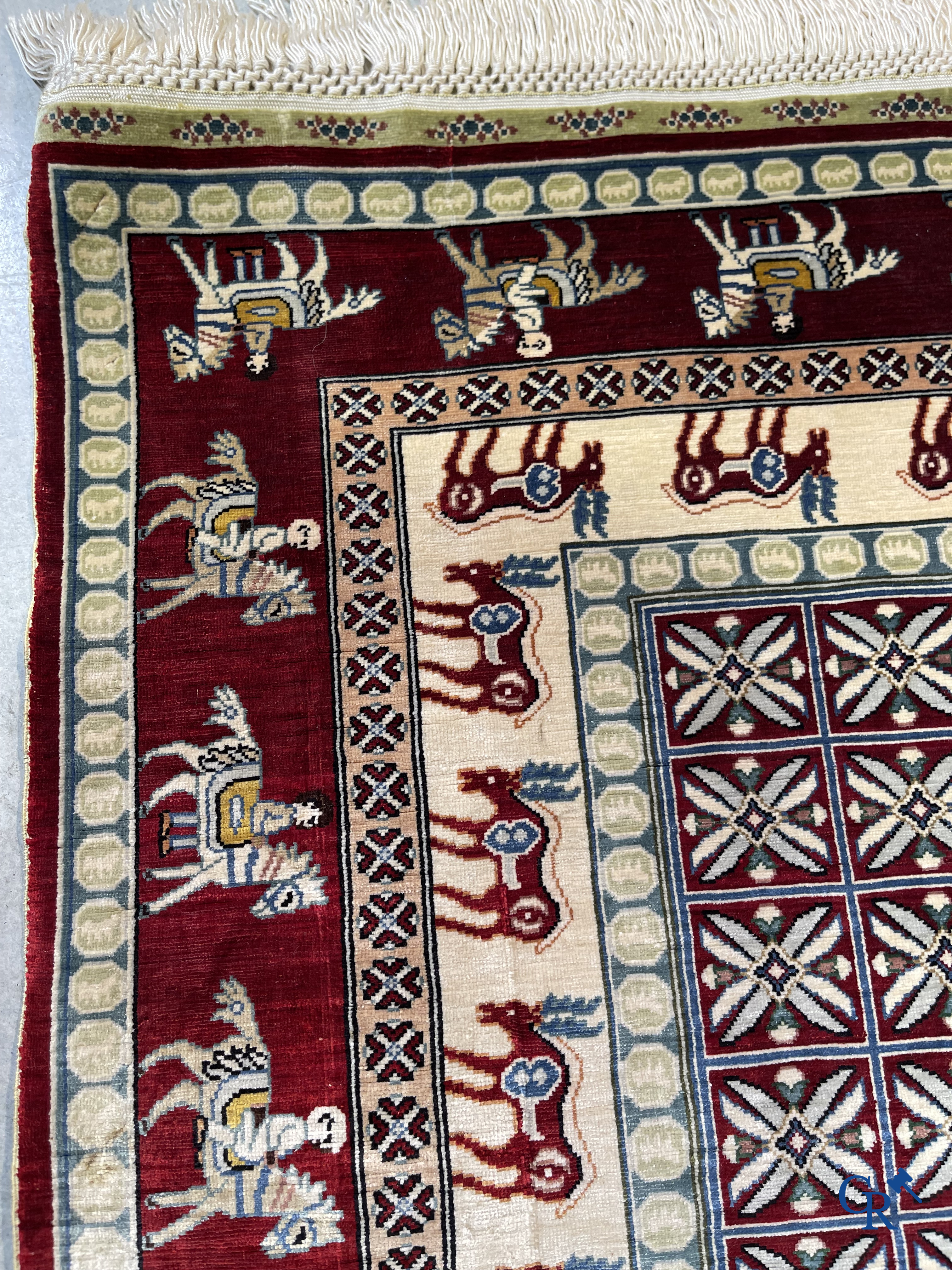 Oriental rugs: A small finely hand-knotted silk rug with deer and horsemen. Signed.