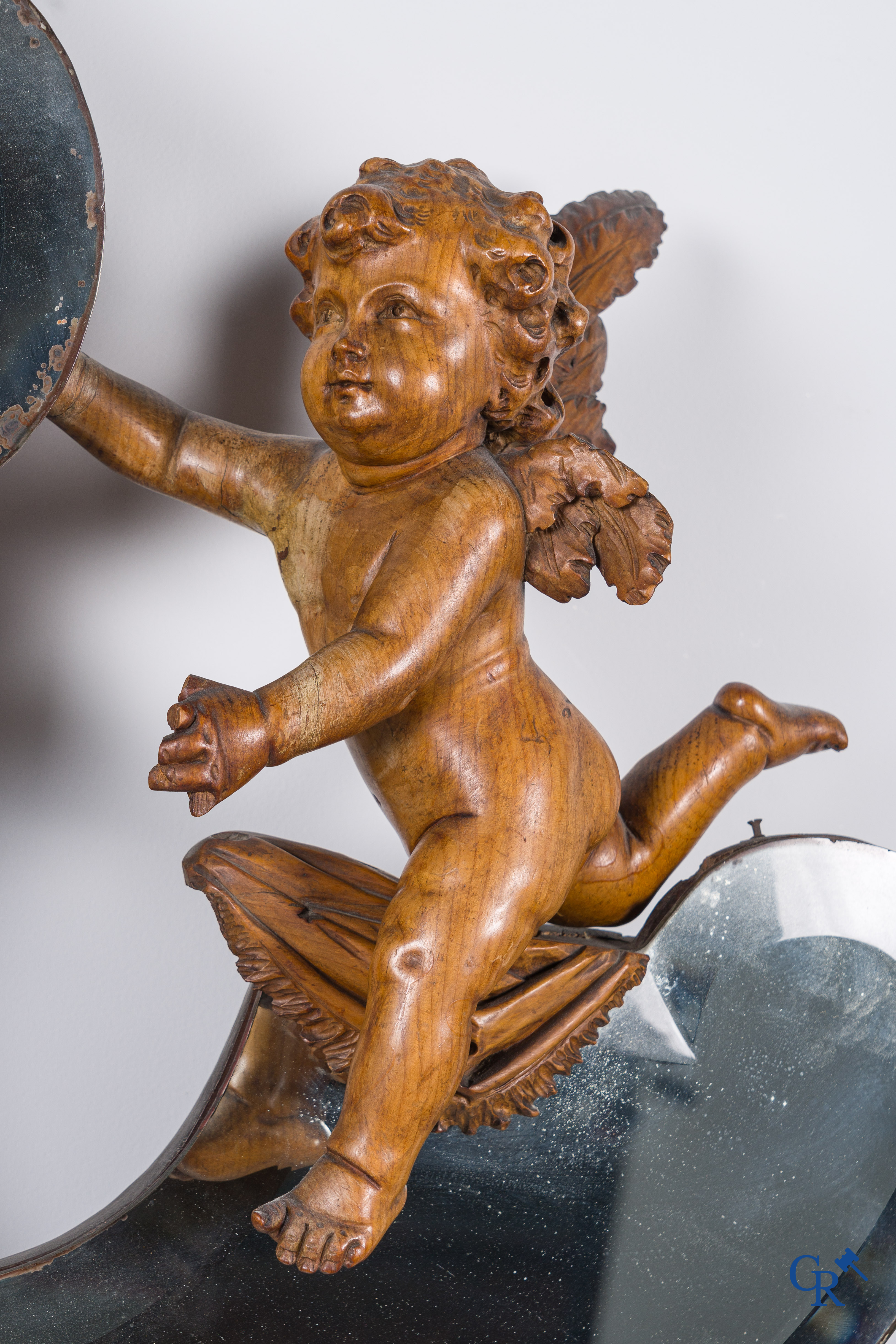 Een grote spiegel omringd met 6 hout gesculpteerde putti. Circa 1900.