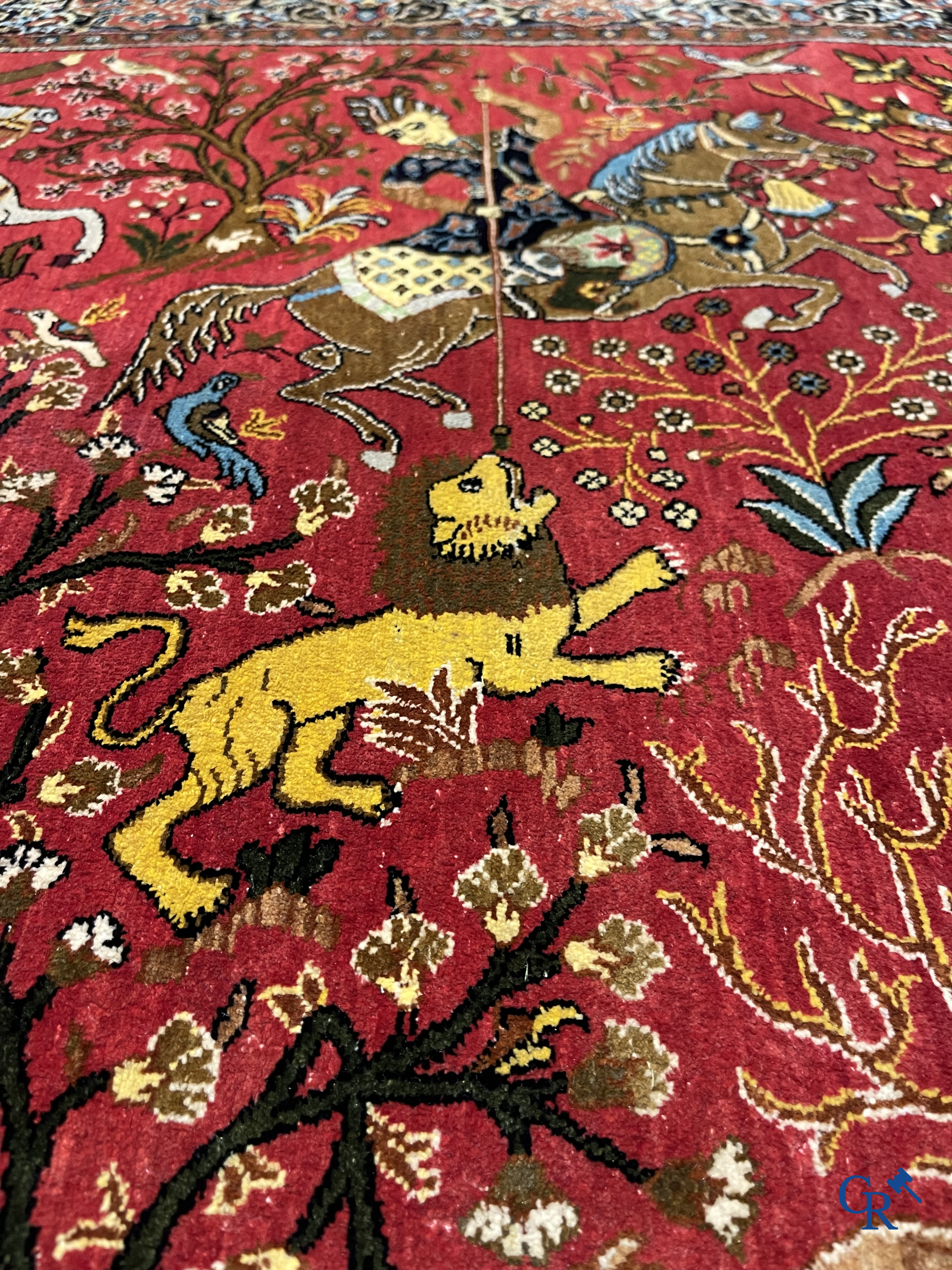 Oriental carpets, a Persian carpet in silk with a scene of hunters on horseback.