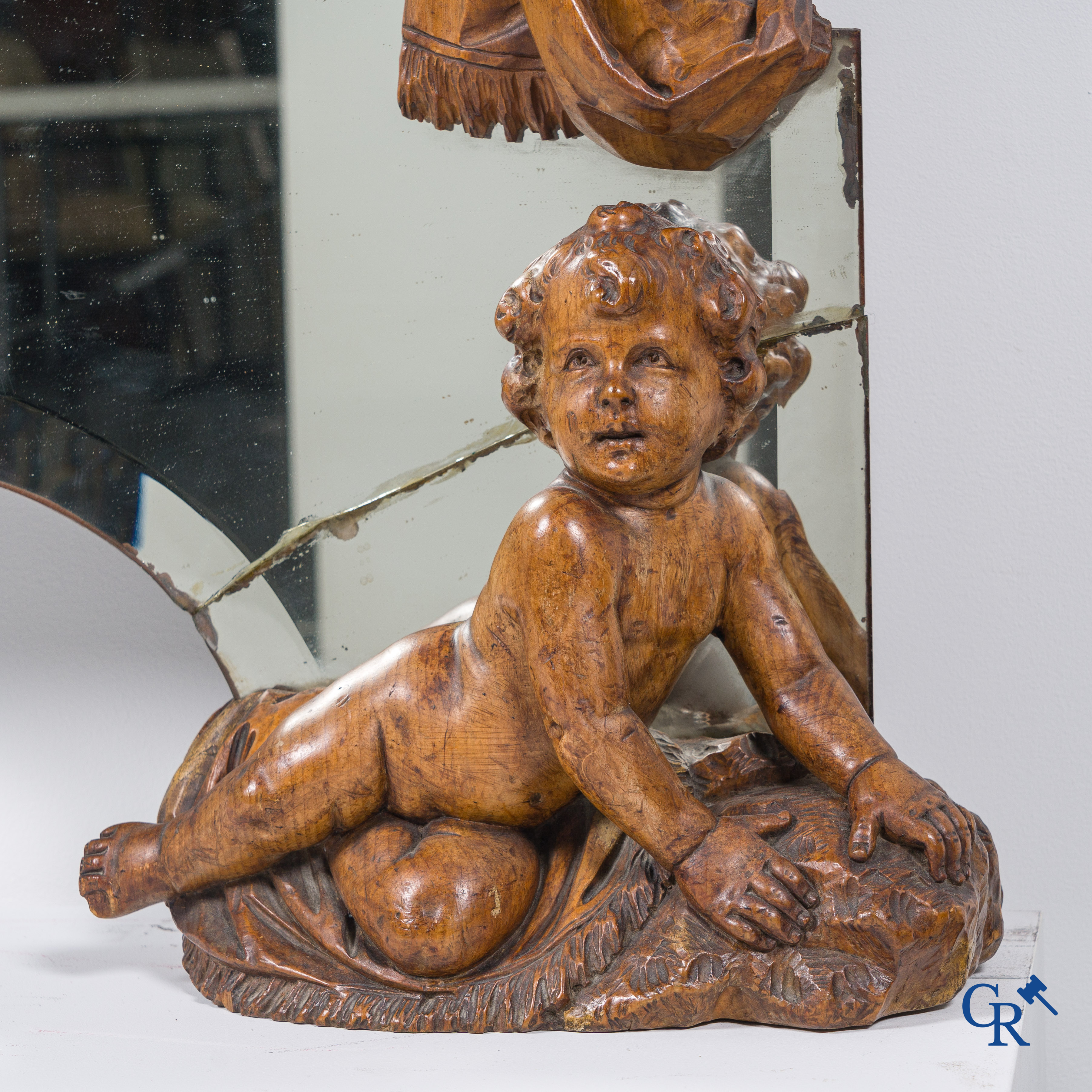 Un grand miroir entouré de 6 putti en bois sculpté. Vers 1900.