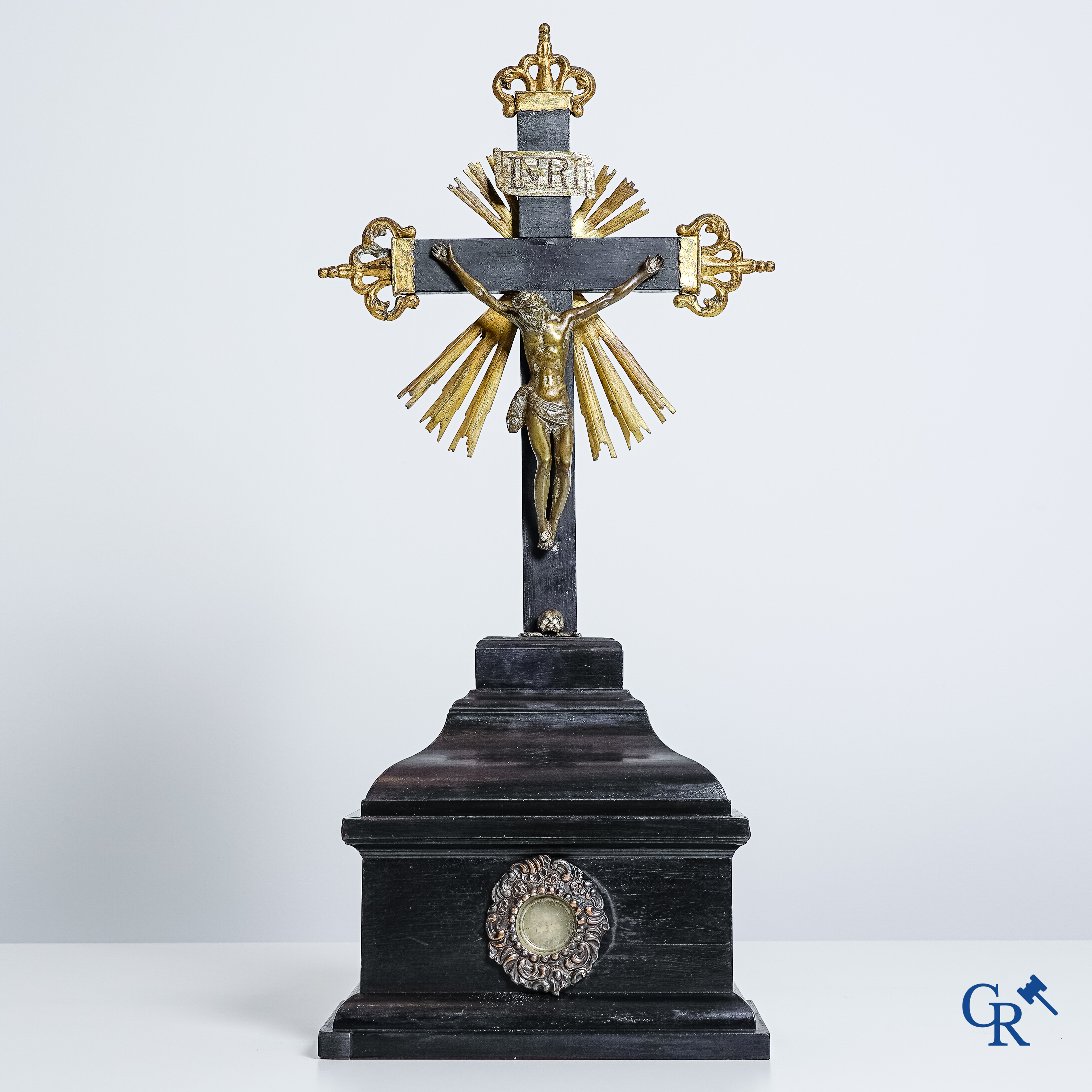 Religious objects: Bronze Christ on the cross held up by an ebony reliquary with relic.