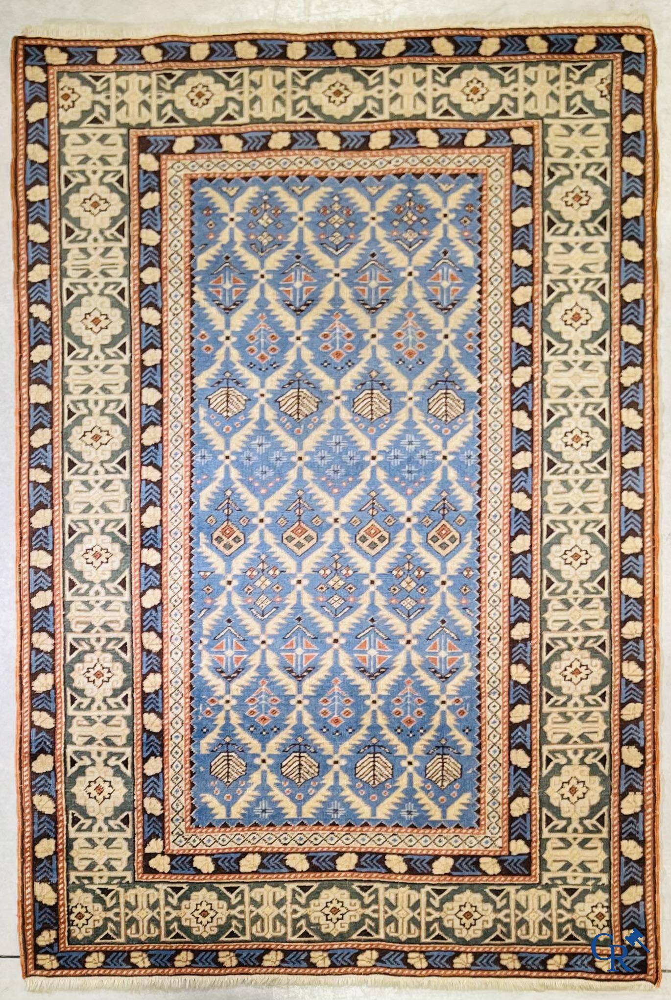 Antique Oriental carpets, an antique Dagestan carpet with motifs on a blue background.