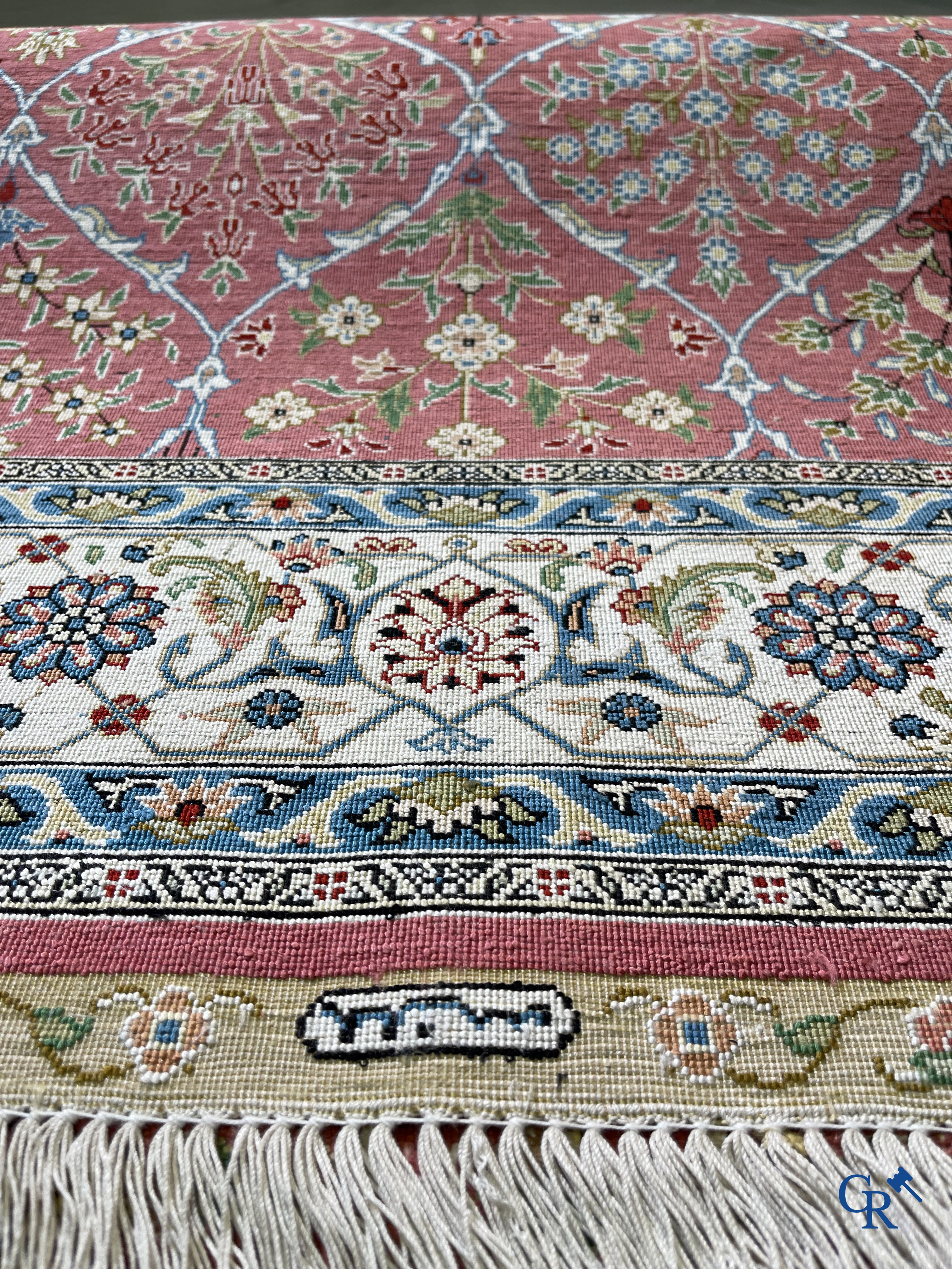 Tapis d'Orient: Un tapis finement noué à la main en laine et soie avec un décor floral.<br />
Signé.