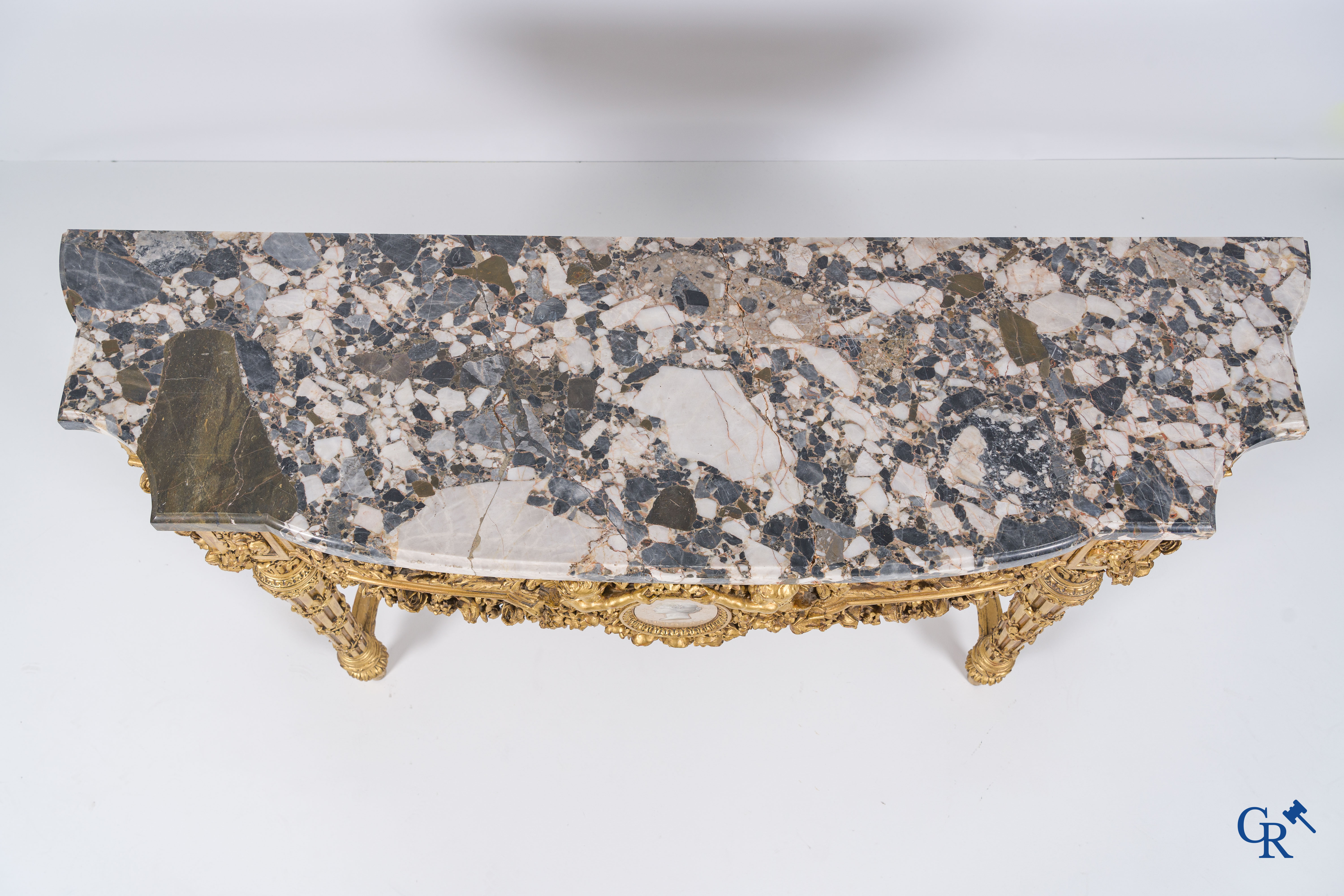 A richly carved and gilded console table in LVXI style with a grisaille painting on marble.