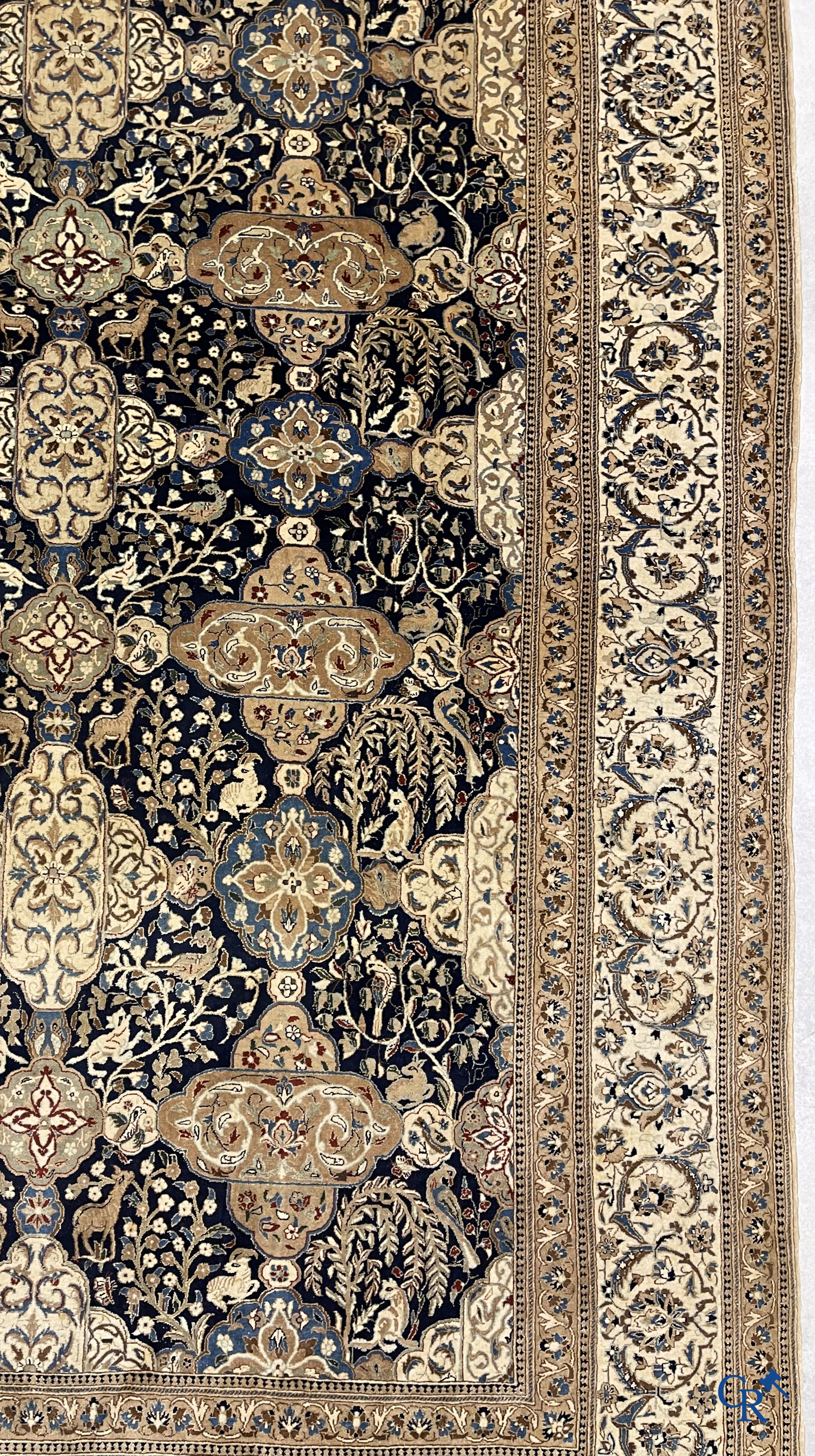 Oosterse tapijten. Een handgeknoopt tapijt met wouddieren en bloemen.