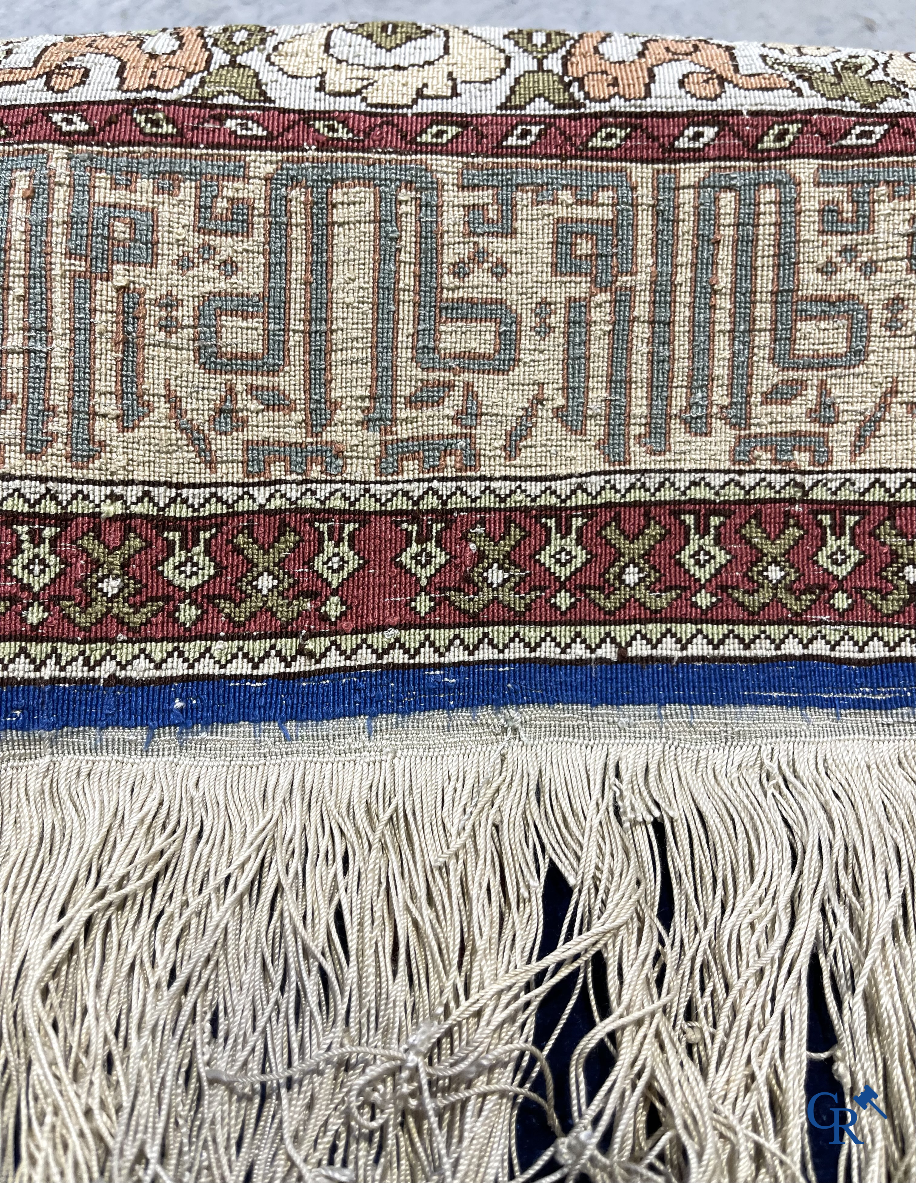 Oosterse tapijten. Een uiterst fijn handgeknoopt zijden tapijt met inscripties en gouddraad. Gesigneerd.