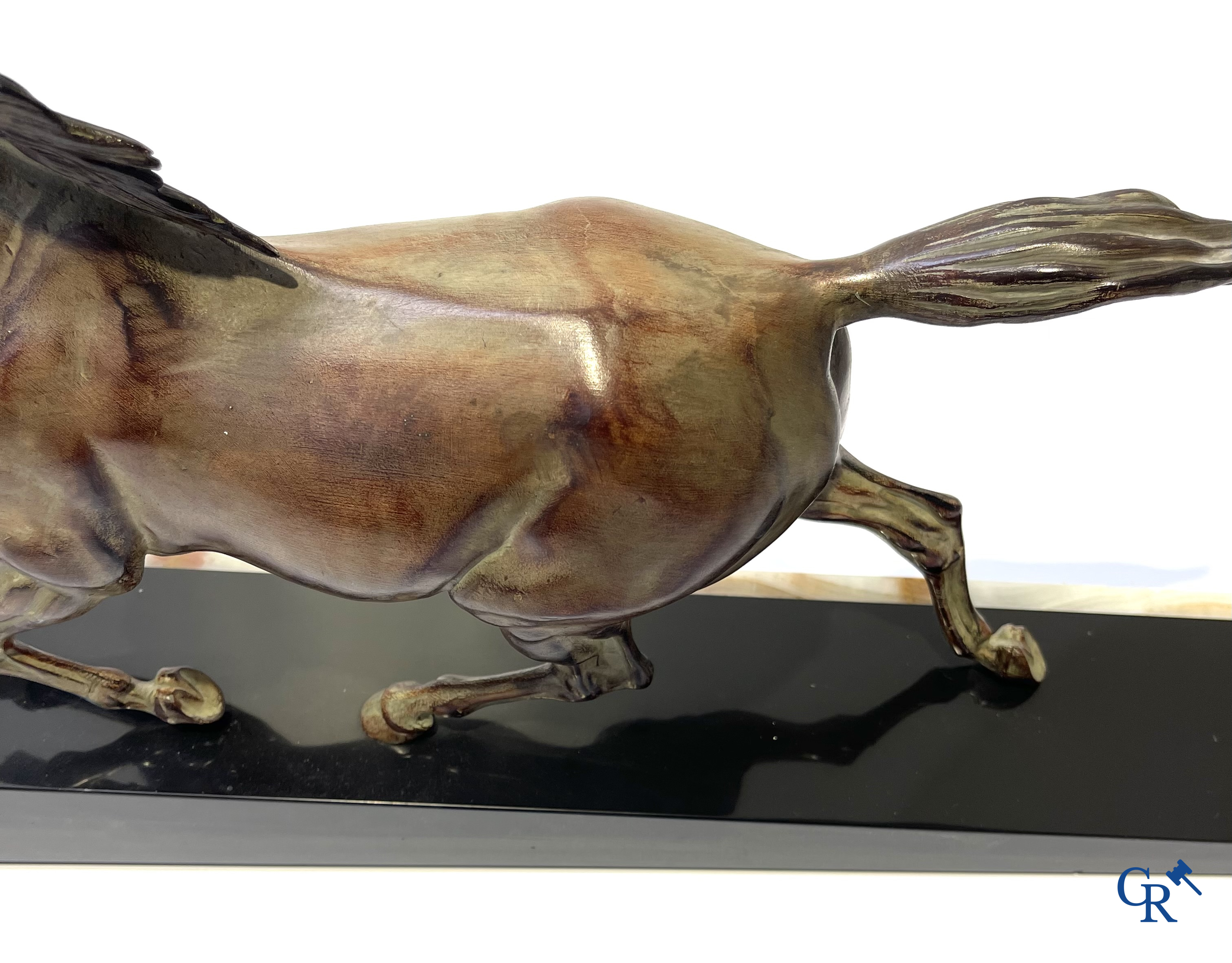 Voorstelling van een lopend paard op een sokkel in zwarte marmer en onyx. Gesigneerd Jonce.