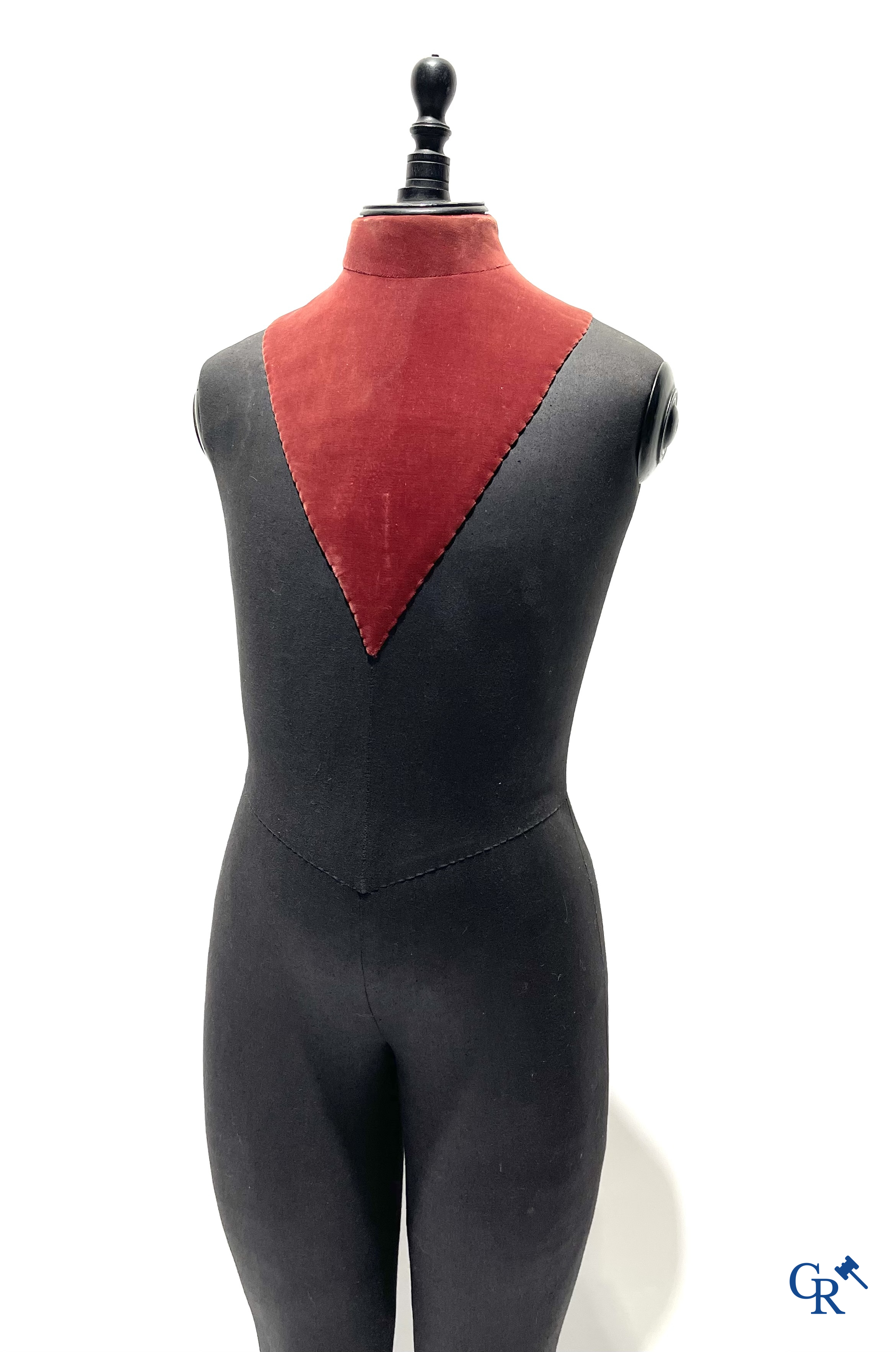 Een kindermannequin met houten laarzen en zwarte stof in de stijl van Stockman. Circa 1900.