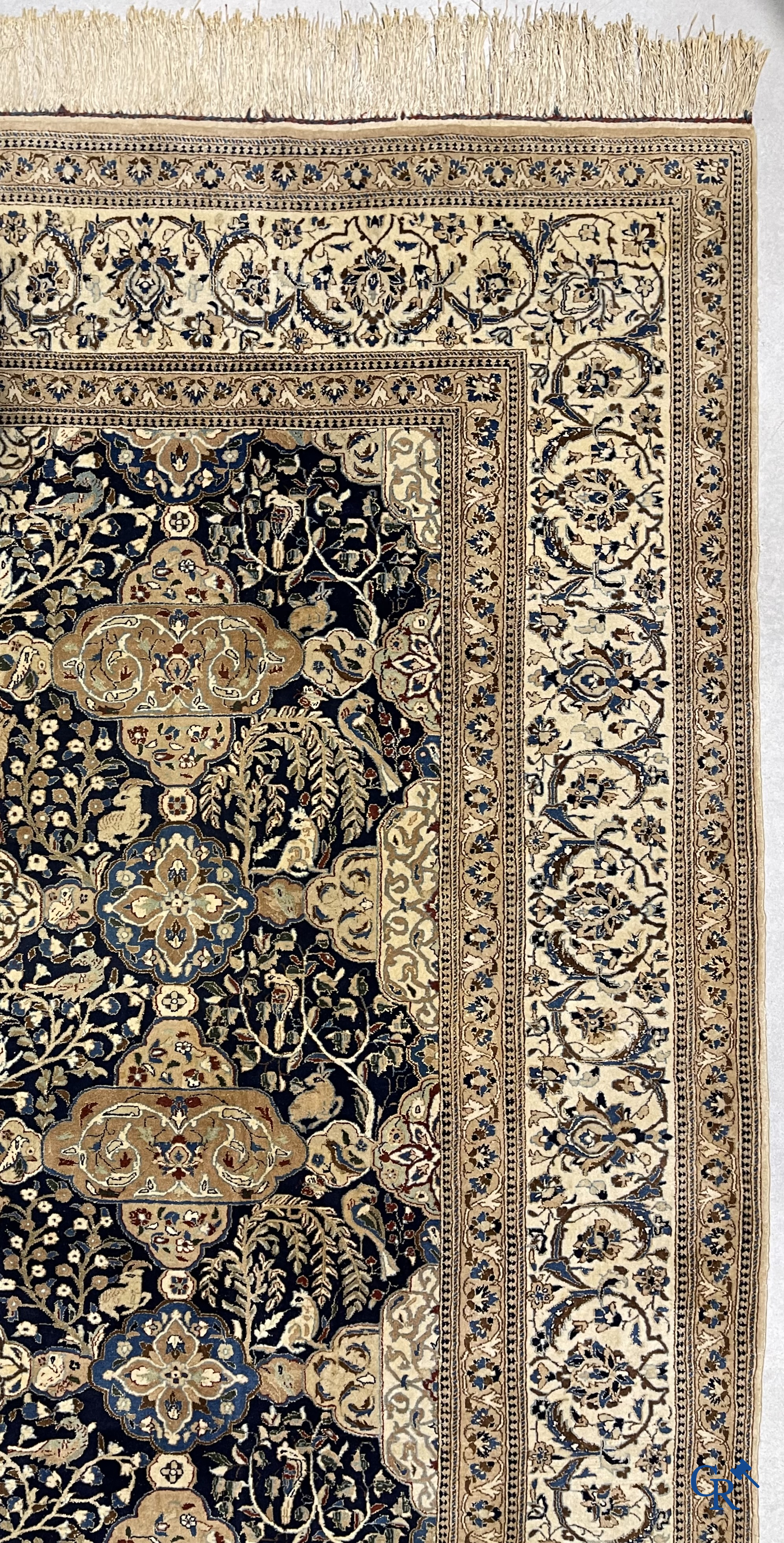 Oosterse tapijten. Een handgeknoopt tapijt met wouddieren en bloemen.