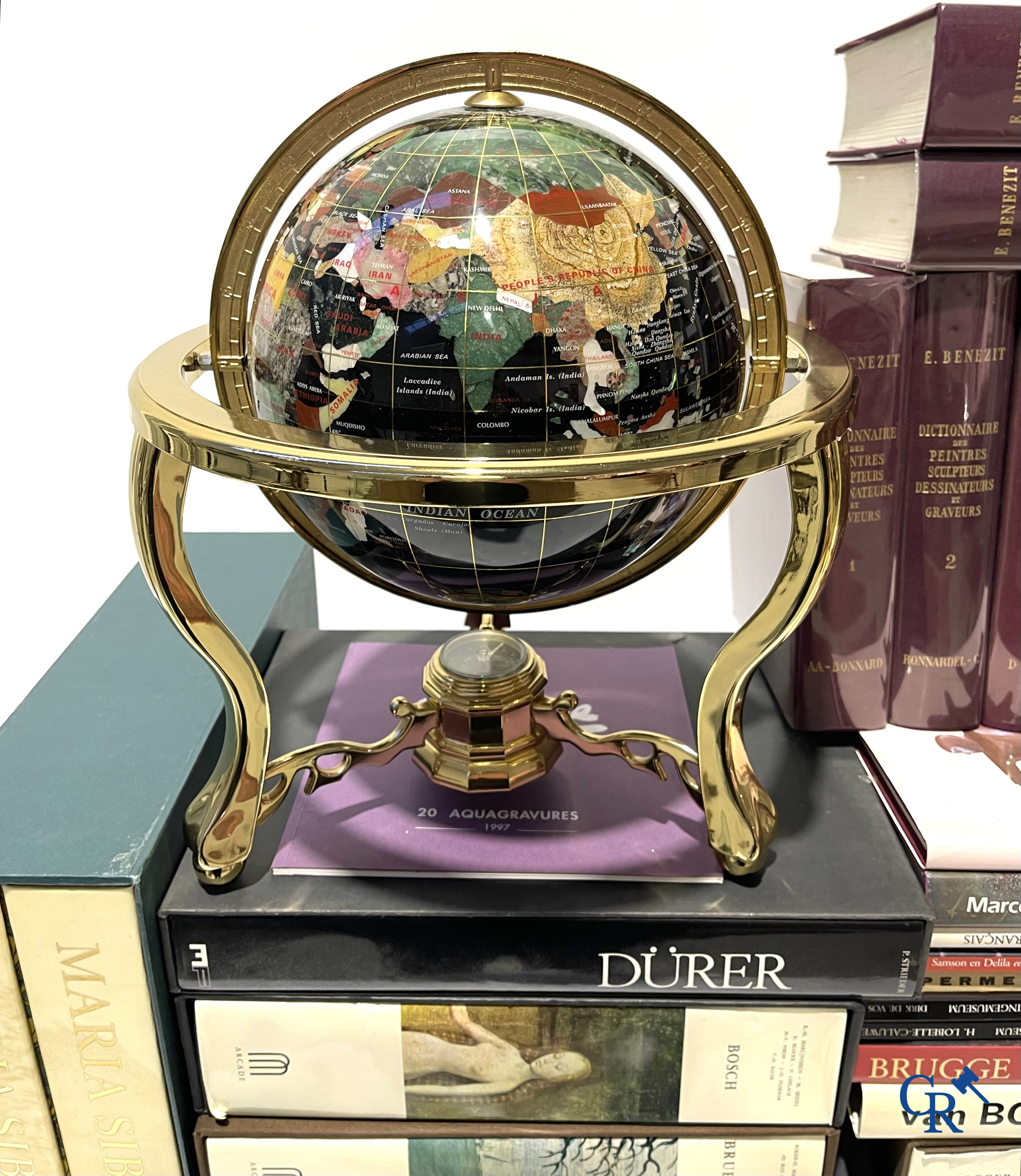 Groot lot kunstboeken, het Bénézit-woordenboek en een decoratieve moderne wereldbol.