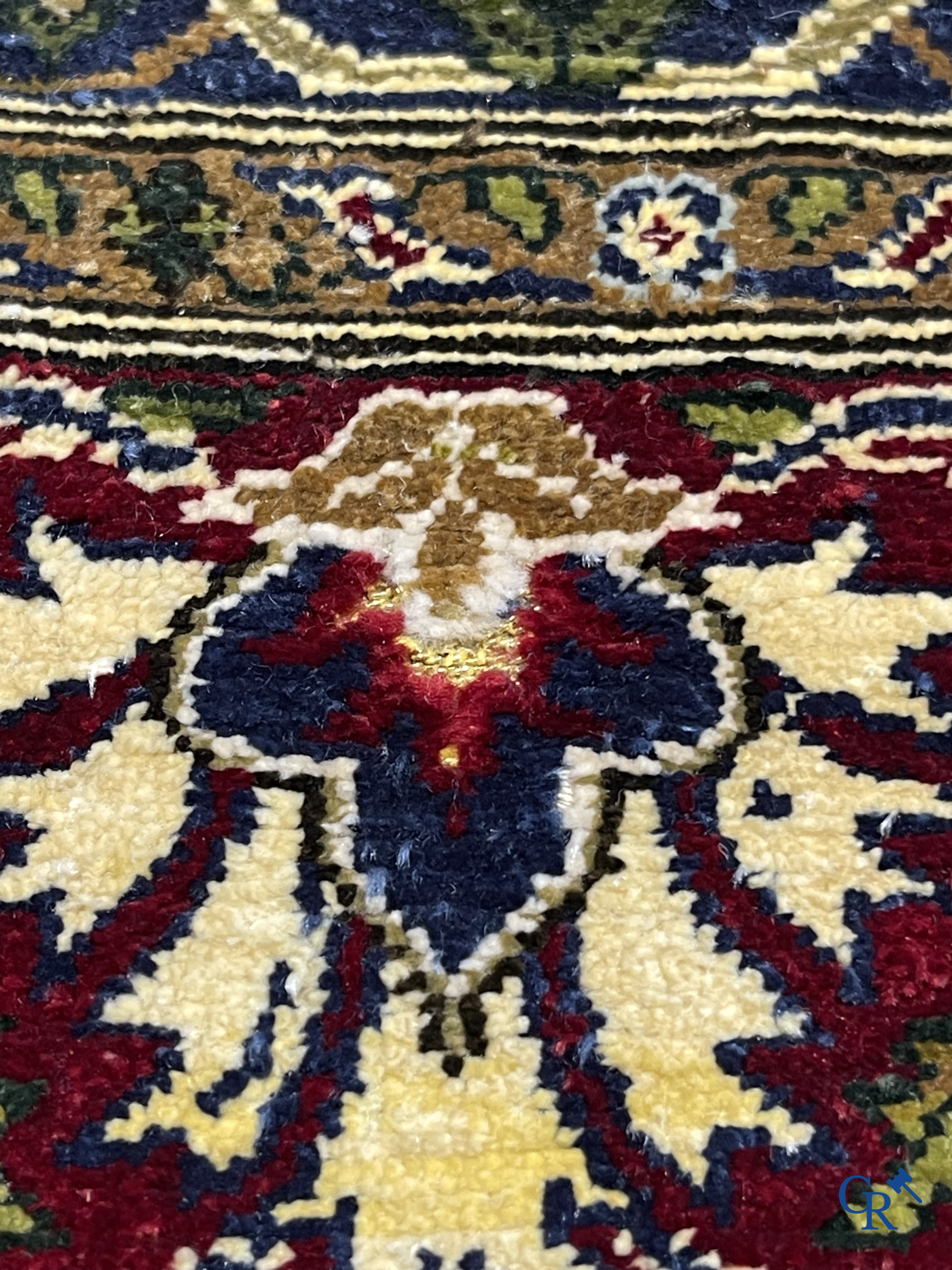 Oosterse tapijten. Een uiterst fijn geknoopt zijden tapijt met floraal decor op donker blauwe achtergrond en gouddraad.