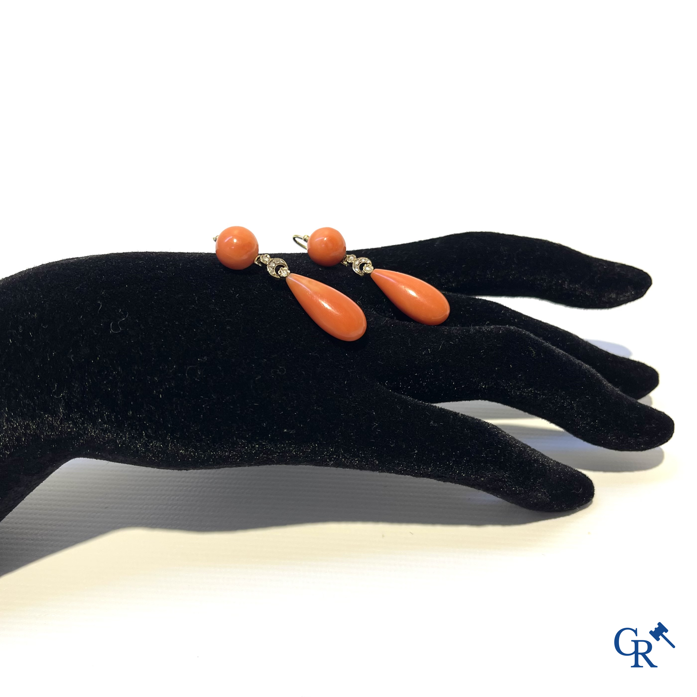 Juwelen. Een paar Art Deco oorringen in geelgoud 750°/00, kleine briljanten en rode koraal.