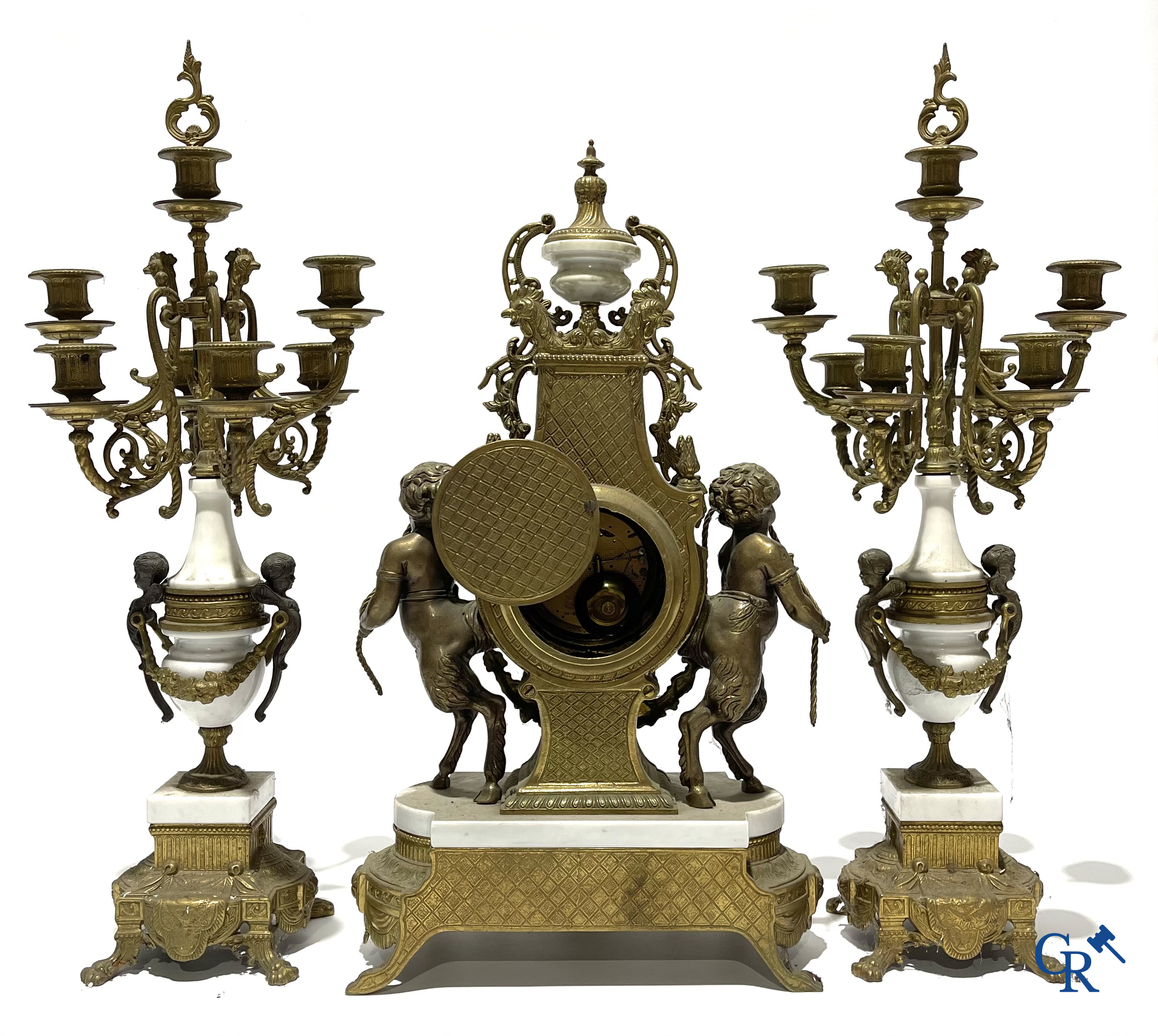 Groot 3-delige schouwgarnituur in brons en marmer met putti op bokkenpoten. LXVI-stijl. 20ste eeuw.<br />
