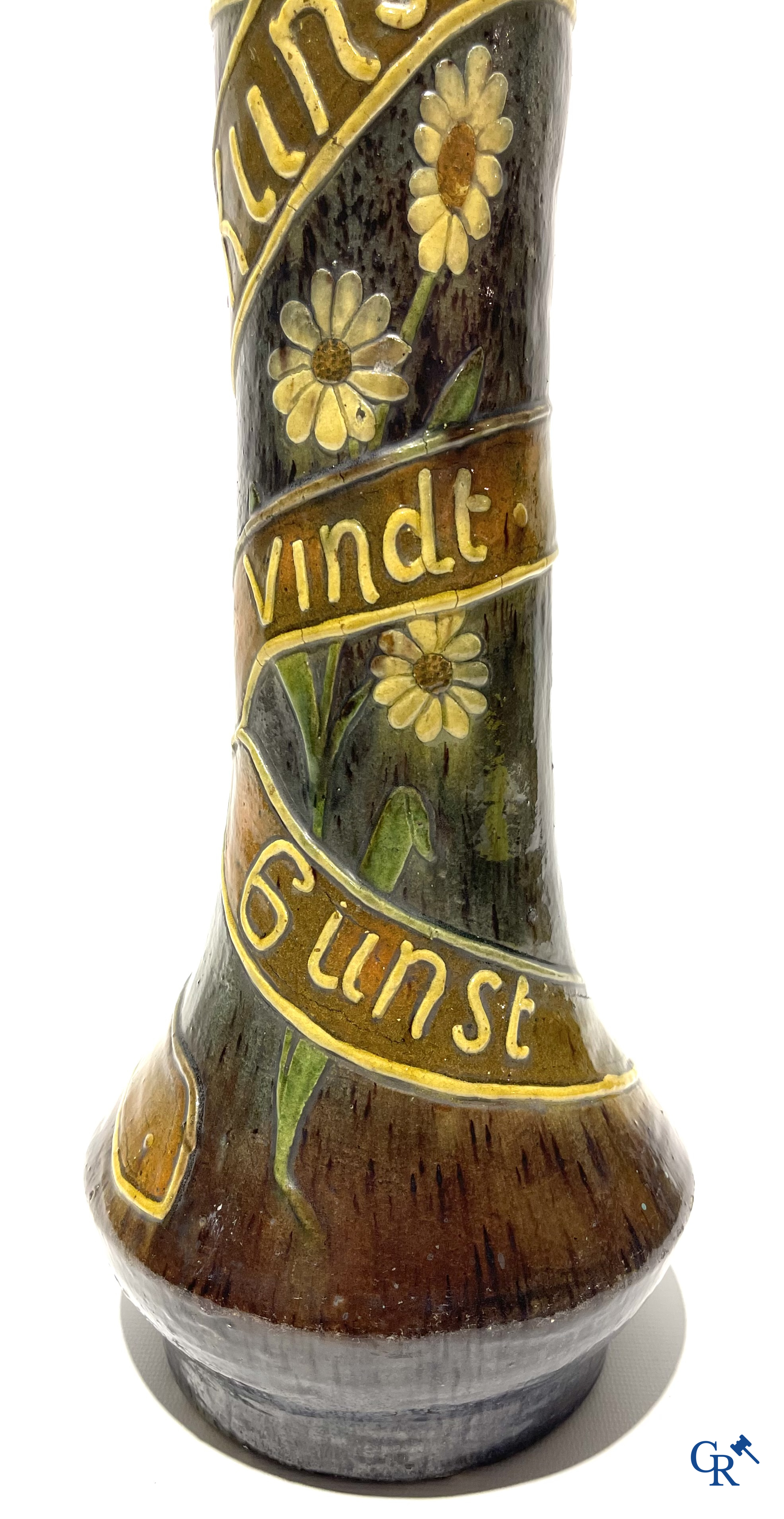 Torhouts aardewerk. Vaas in Vlaams aardewerk met een bloemendecor en spreuk. Gesigneerd LMV voor Leo Maes Vereenooghe.