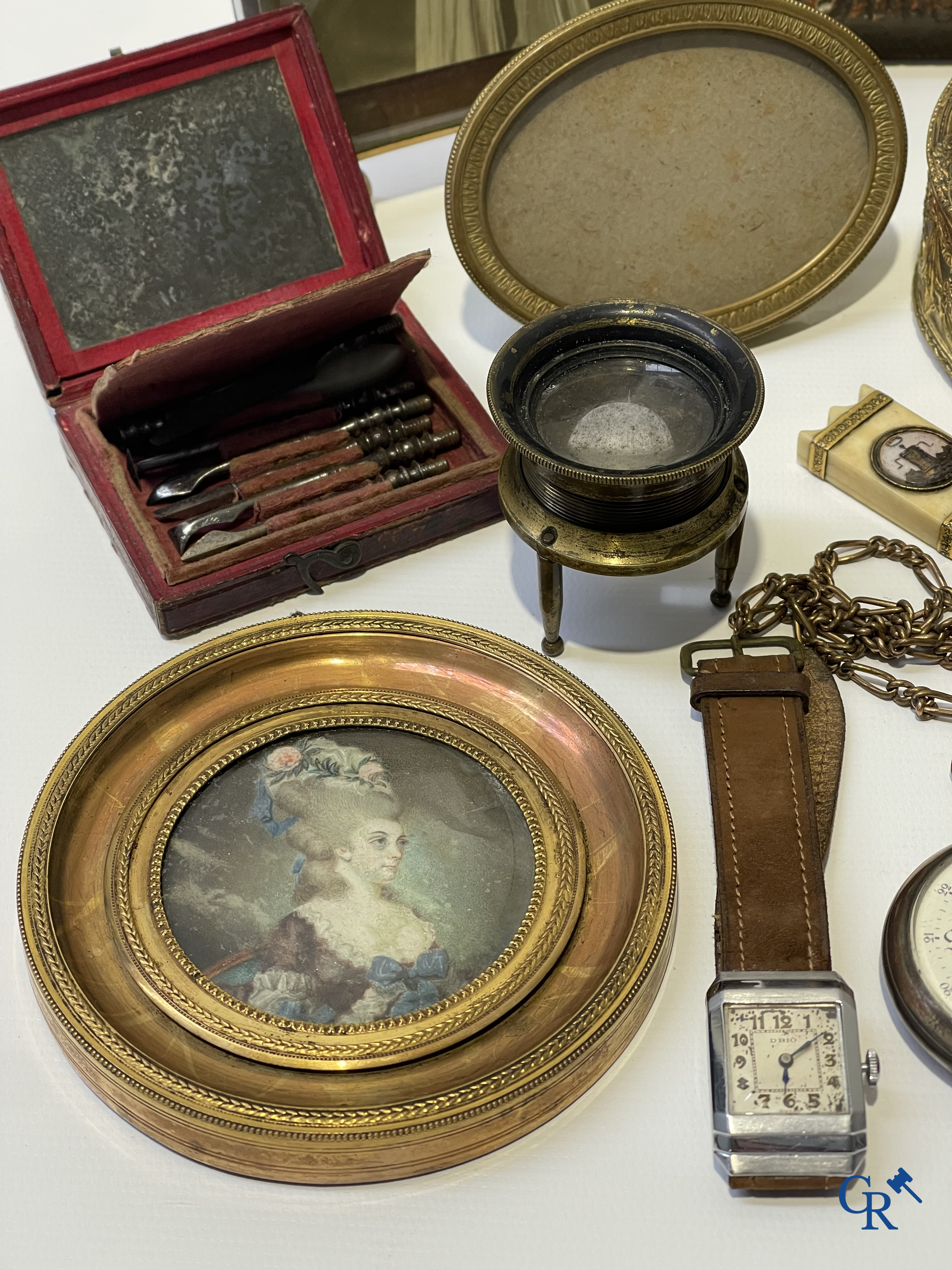 Een uitgebreid lot met vitrineobjecten. Zakhorloges, miniaturen, bronzen kaders, fantasiejuwelen enz. Sommige in zilver.