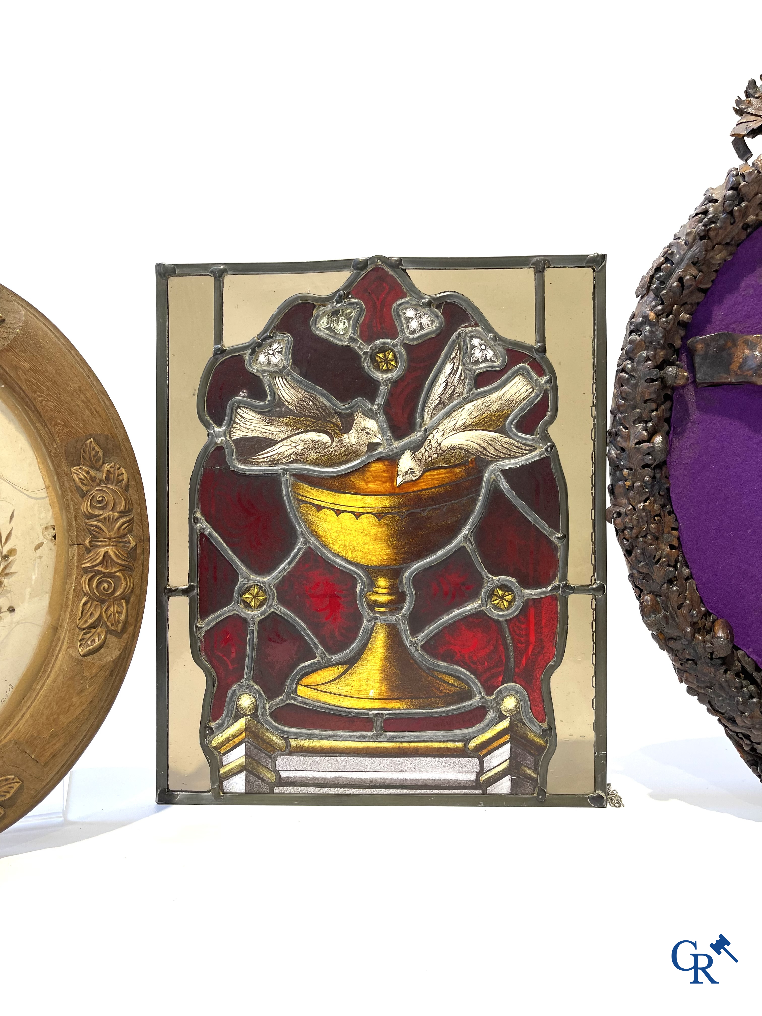 Religieuze objecten. Glas in loodraam met brandglas, kader met kruis in bewerkt leder, ovale kader als souvenir.