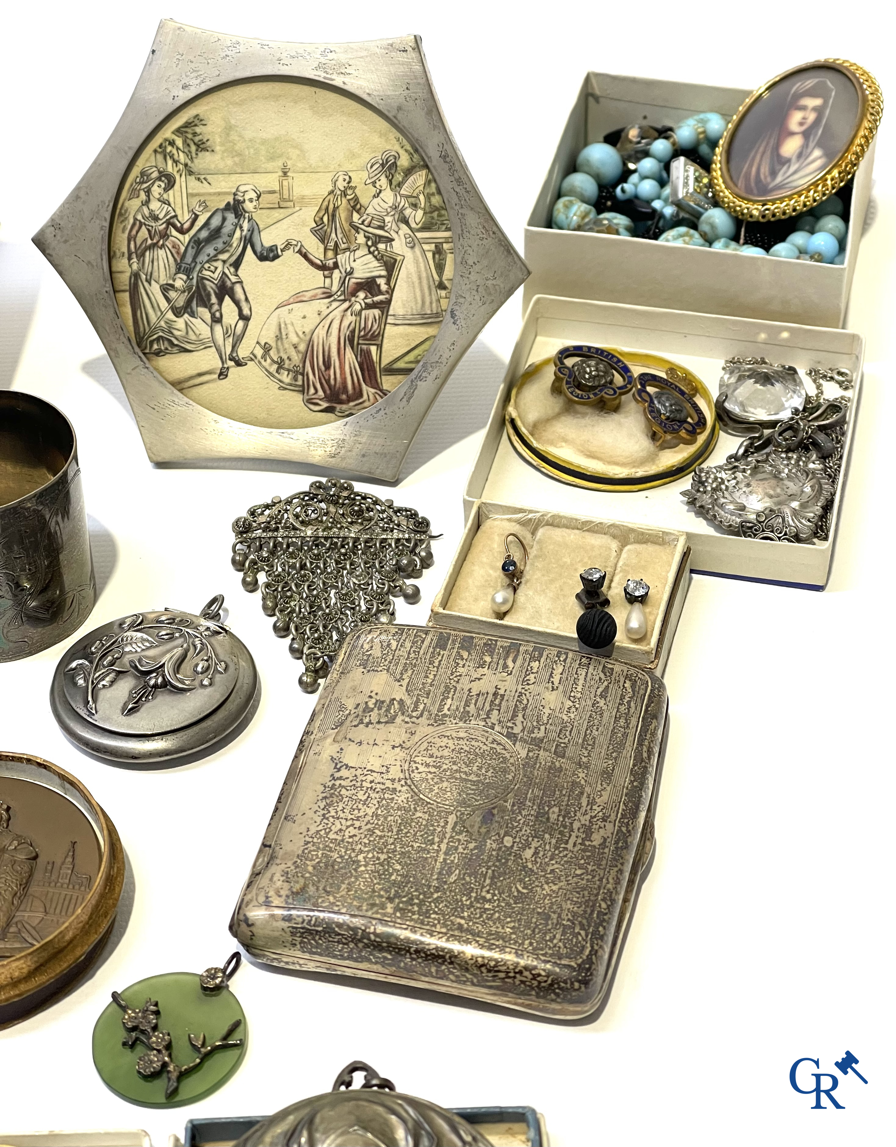 Een uitgebreid lot met vitrineobjecten. Zakhorloges, miniaturen, bronzen kaders, fantasiejuwelen enz. Sommige in zilver.