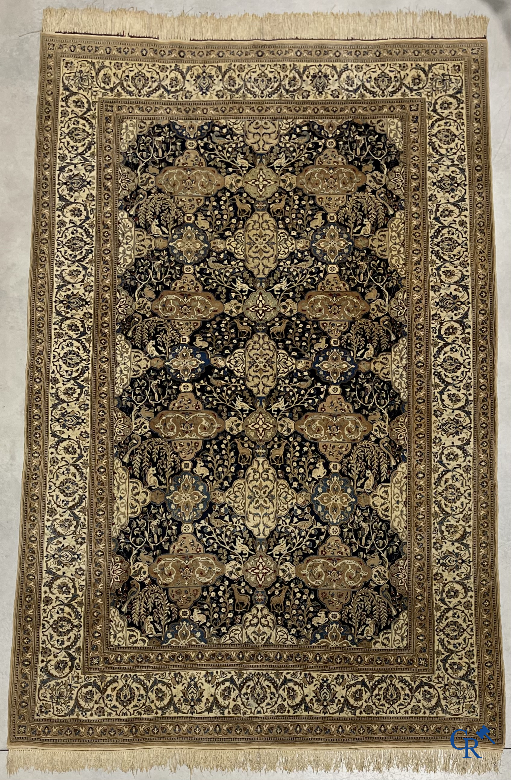 Oosterse tapijten. Een handgeknoopt tapijt met wouddieren en bloemen.