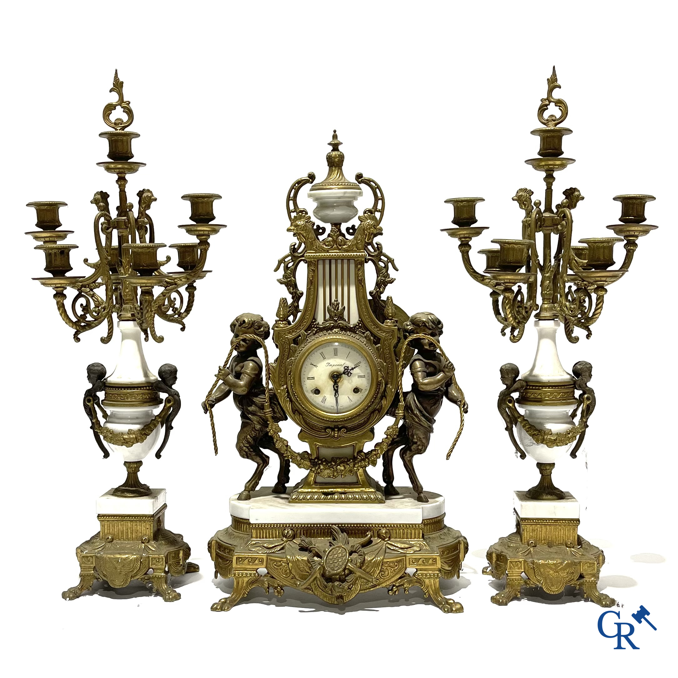 Groot 3-delige schouwgarnituur in brons en marmer met putti op bokkenpoten. LXVI-stijl. 20ste eeuw.
