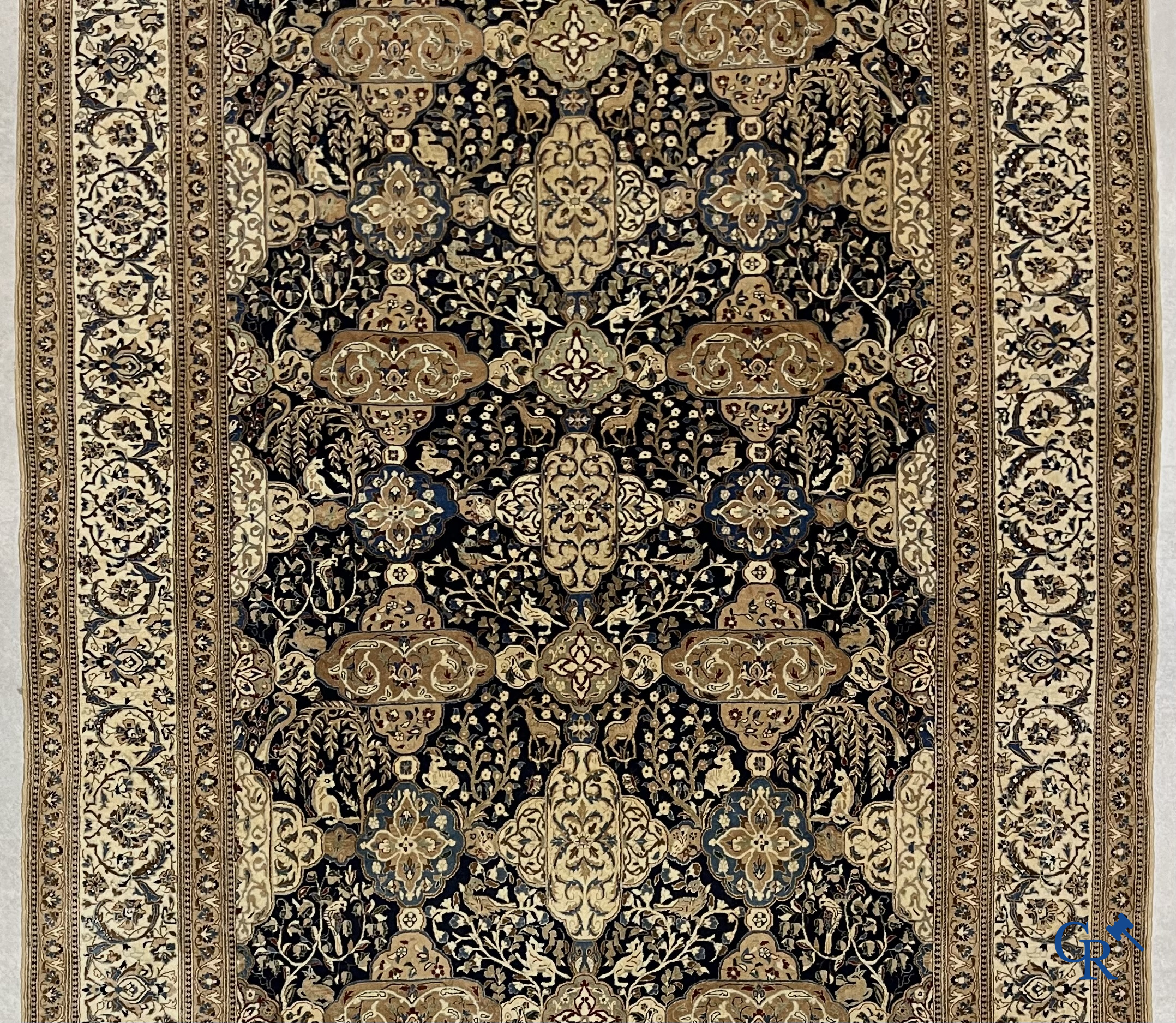 Oosterse tapijten. Een handgeknoopt tapijt met wouddieren en bloemen.