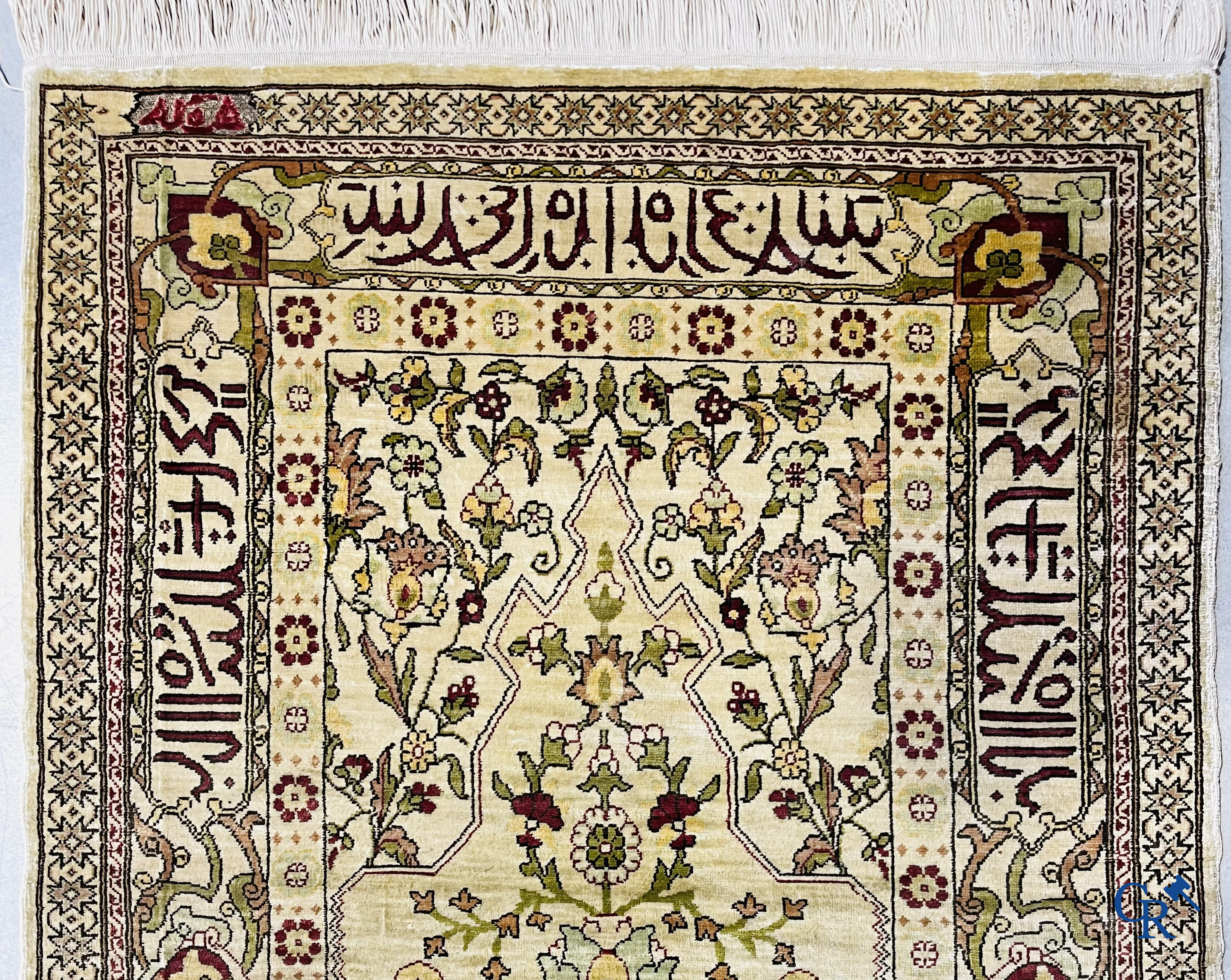 Oosterse tapijten. Hereke, een zijden tapijtje met inscripties. Gesigneerd.