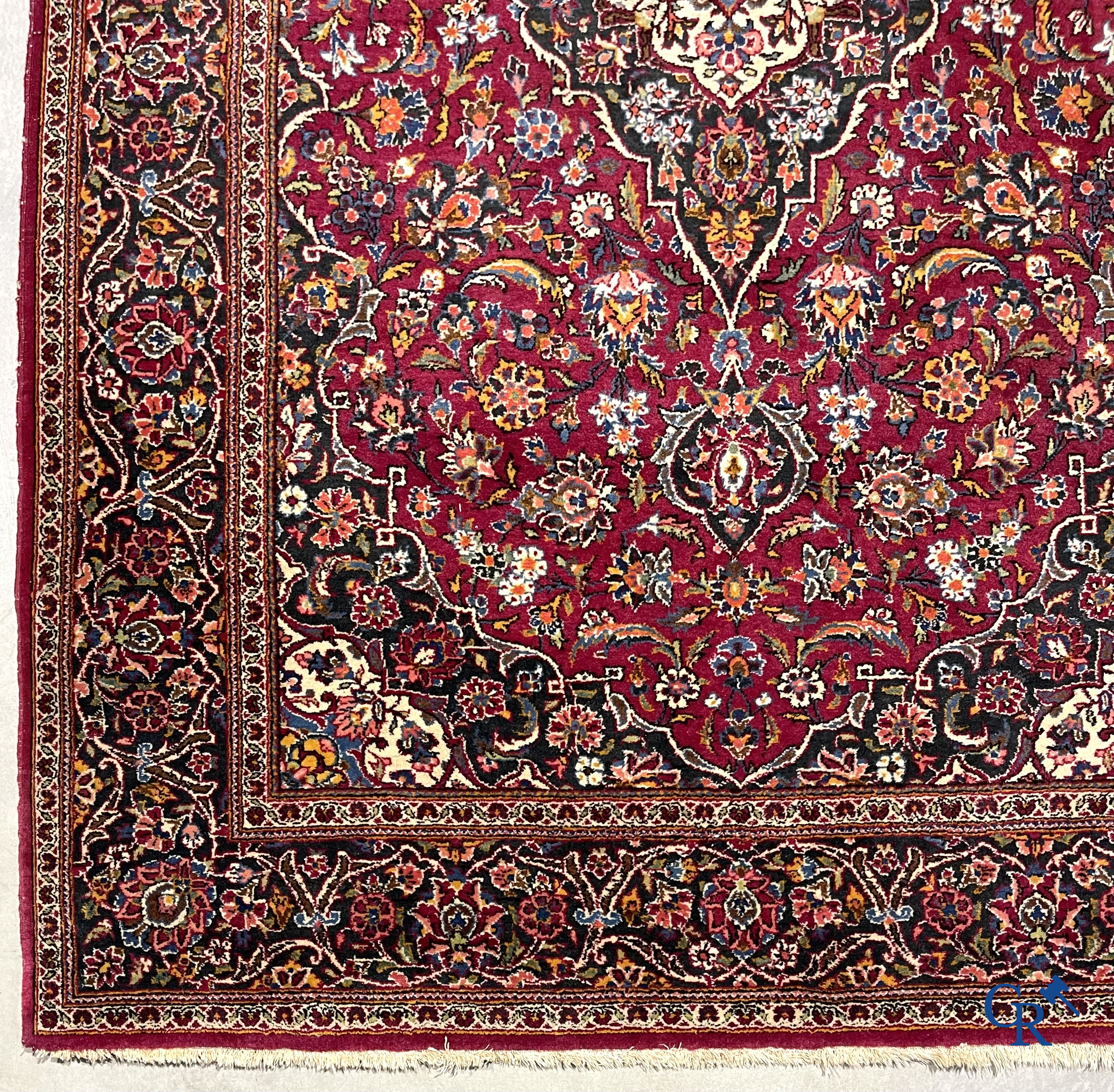 Oosterse tapijten. Een handgeknoopt oosters tapijt met floraal decor op rode achtergrond.