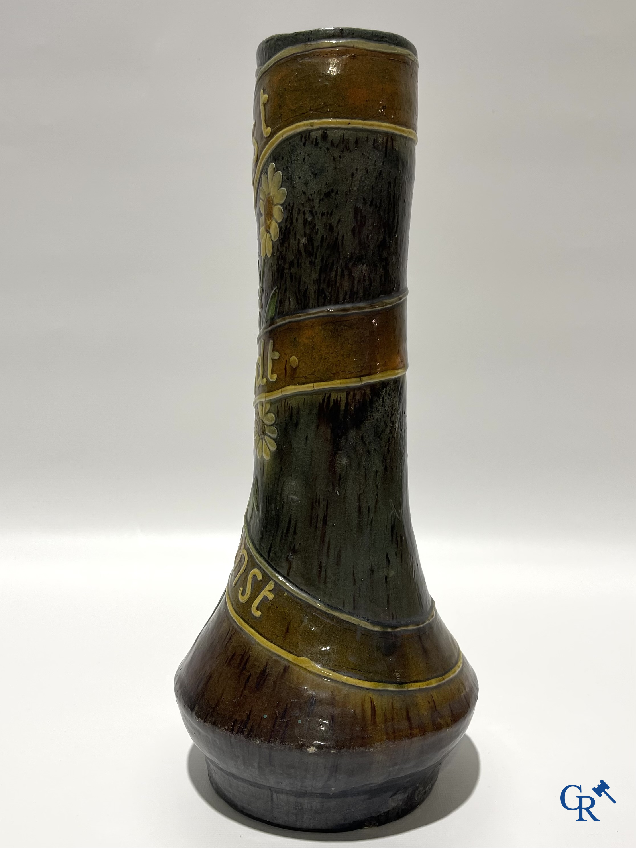 Torhouts aardewerk. Vaas in Vlaams aardewerk met een bloemendecor en spreuk. Gesigneerd LMV voor Leo Maes Vereenooghe.