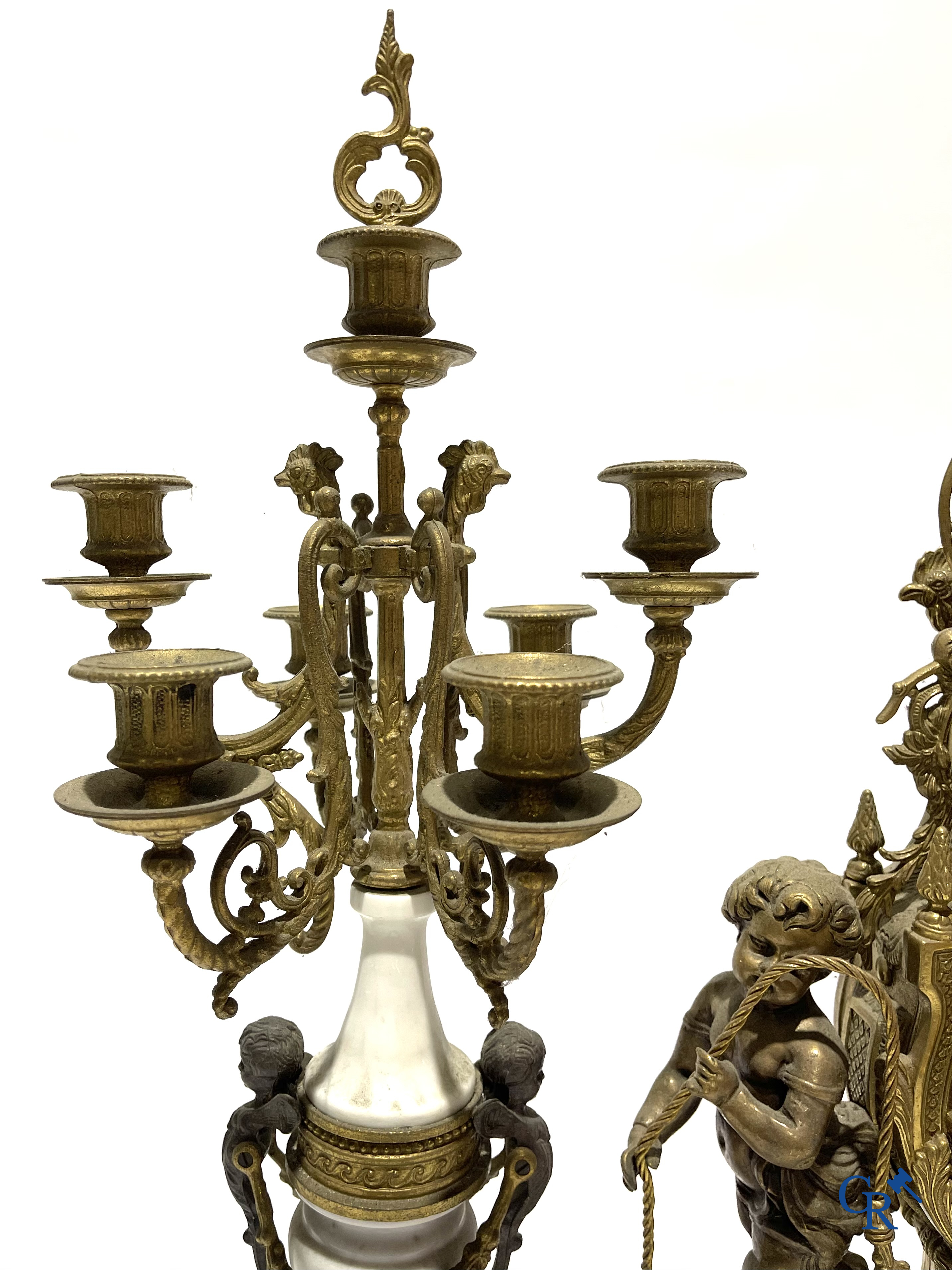 Groot 3-delige schouwgarnituur in brons en marmer met putti op bokkenpoten. LXVI-stijl. 20ste eeuw.<br />
