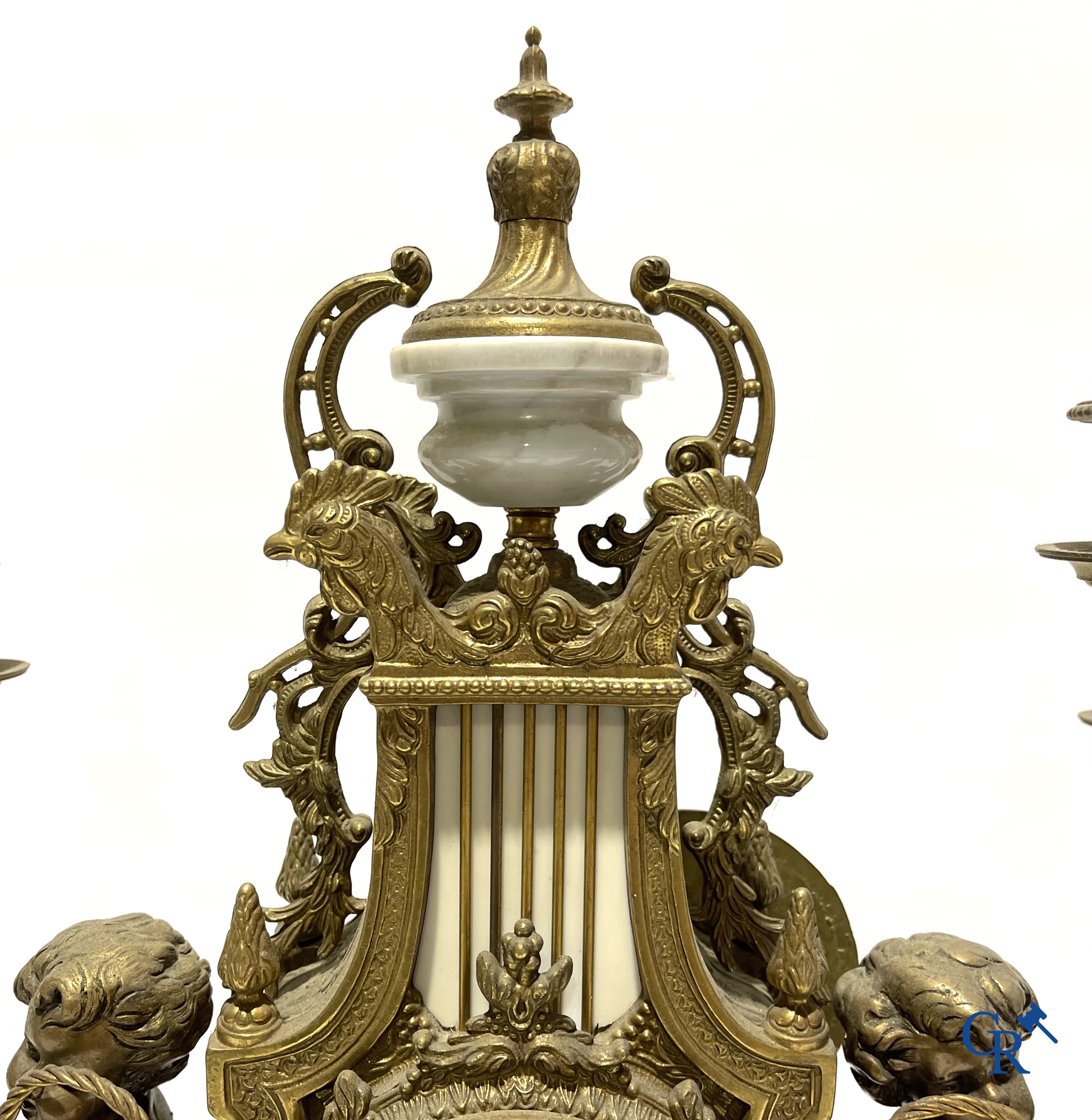 Groot 3-delige schouwgarnituur in brons en marmer met putti op bokkenpoten. LXVI-stijl. 20ste eeuw.<br />
