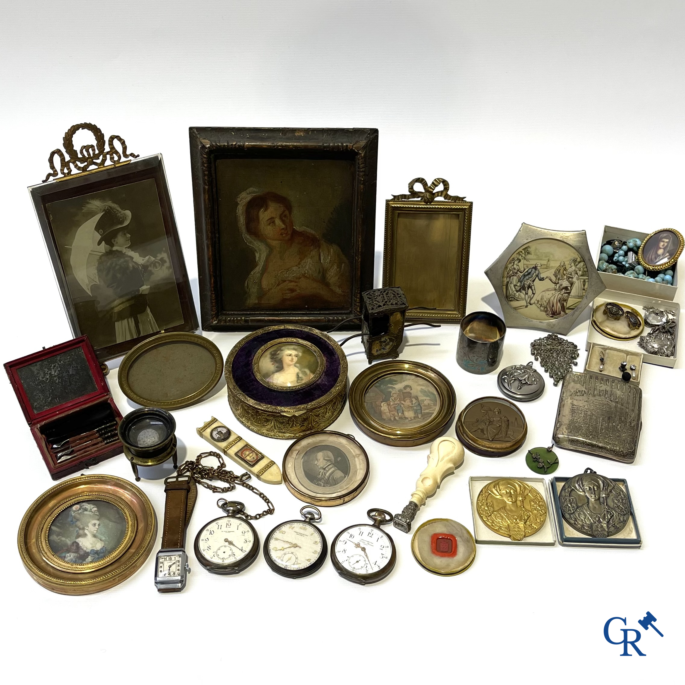 Een uitgebreid lot met vitrineobjecten. Zakhorloges, miniaturen, bronzen kaders, fantasiejuwelen enz. Sommige in zilver.