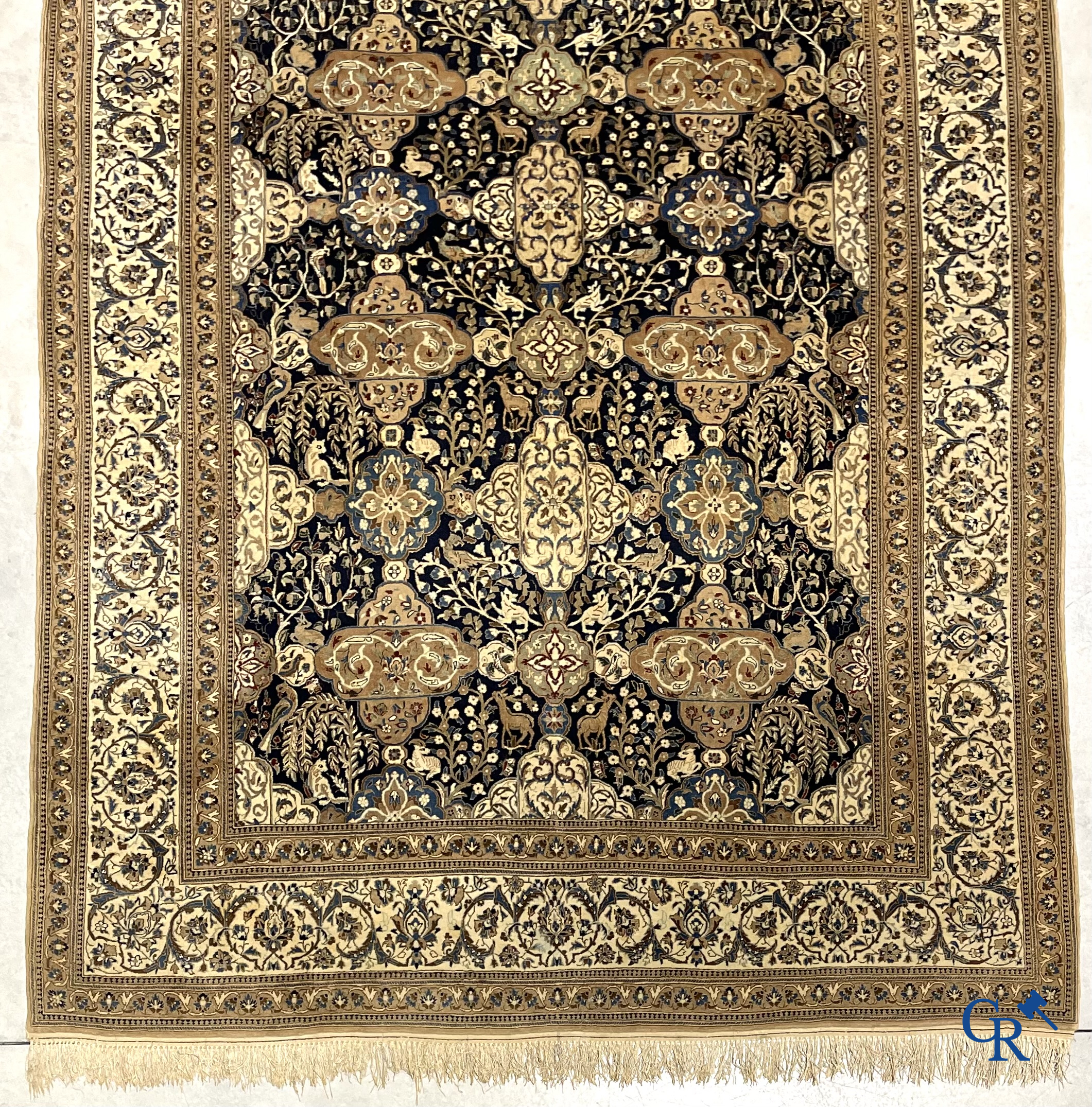 Oosterse tapijten. Een handgeknoopt tapijt met wouddieren en bloemen.