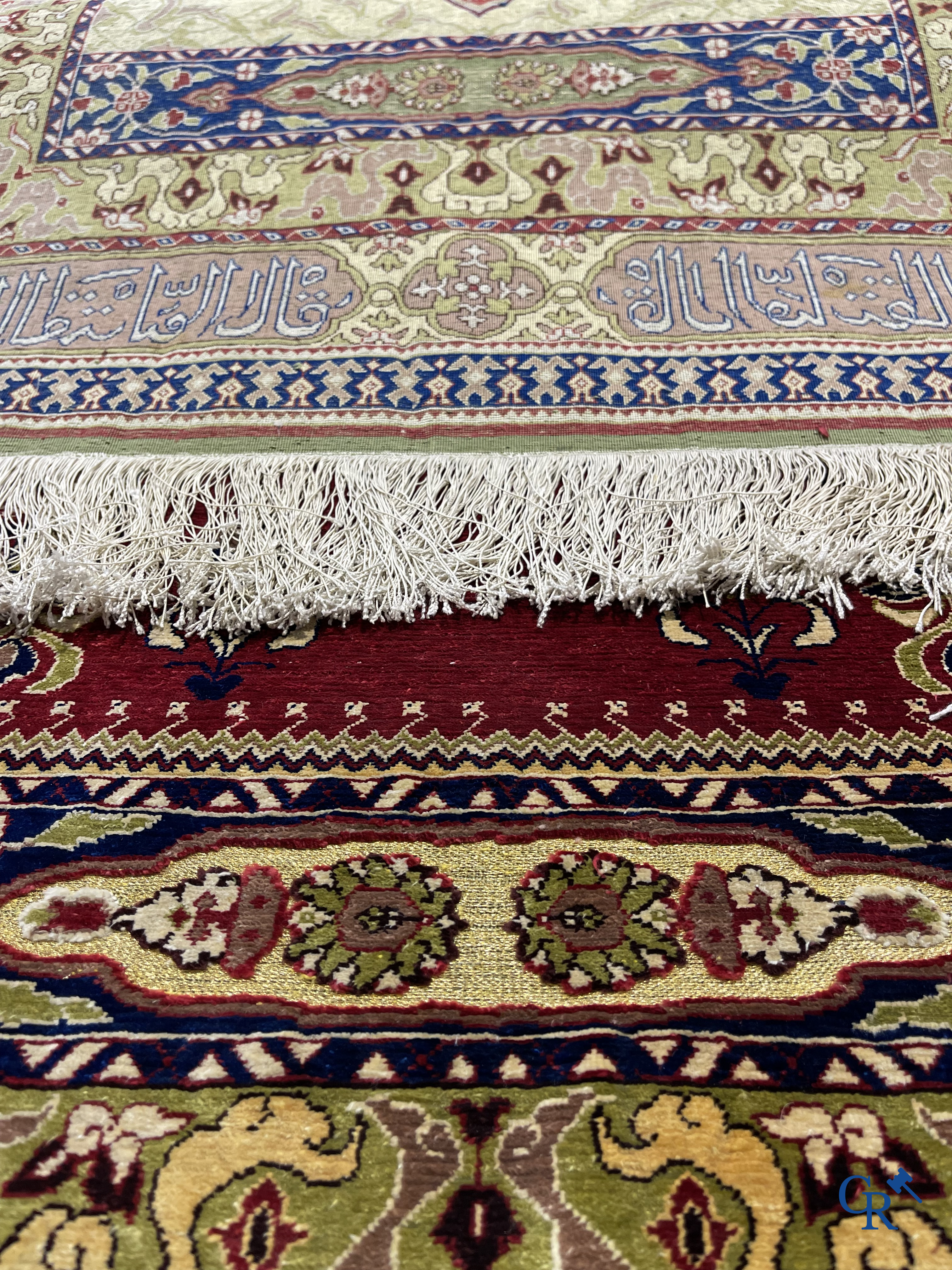 Oosterse tapijten. Een uiterst fijn handgeknoopt zijden tapijt met inscripties en gouddraad. Gesigneerd.