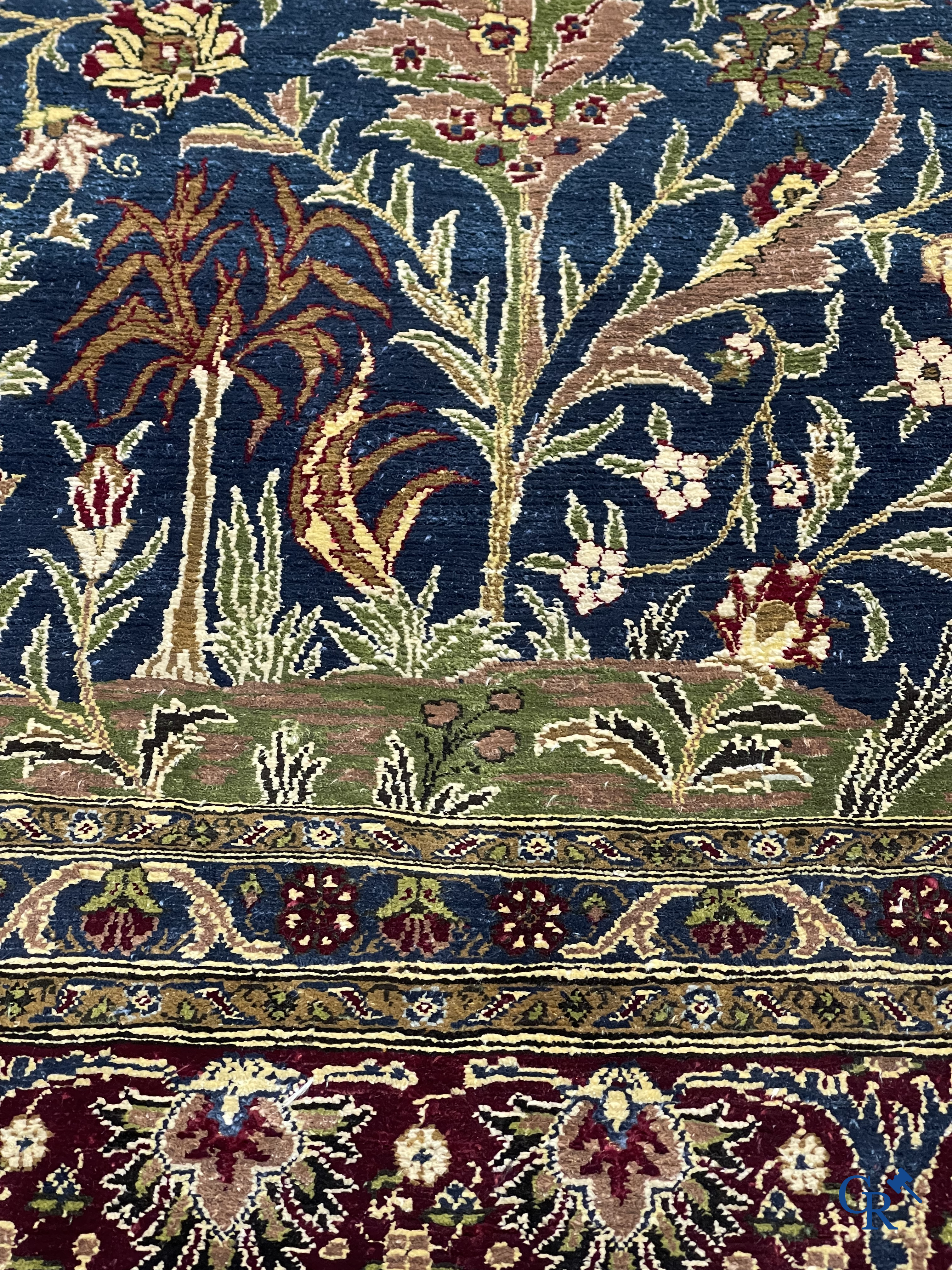 Oosterse tapijten. Een uiterst fijn geknoopt zijden tapijt met floraal decor op donker blauwe achtergrond en gouddraad.