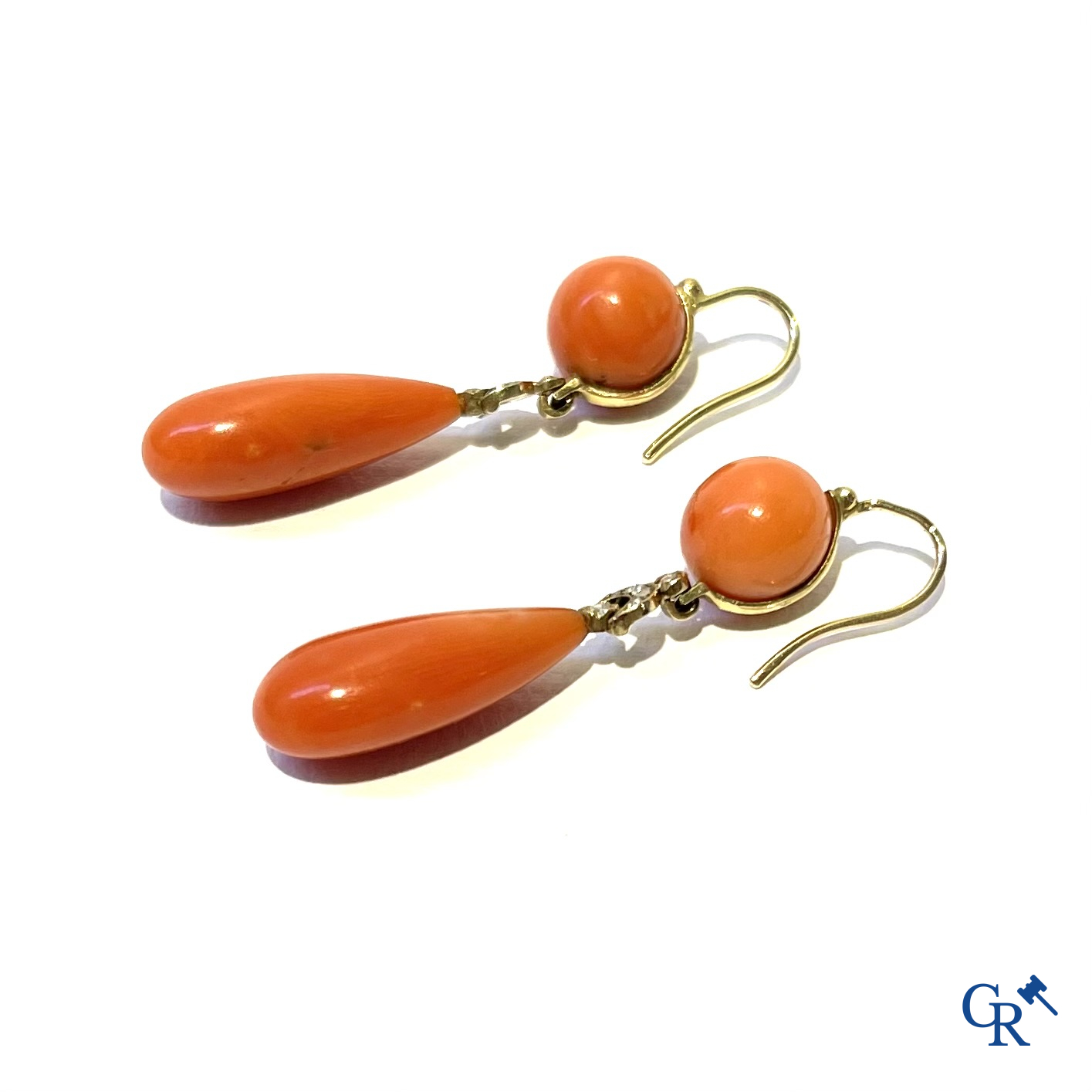 Juwelen. Een paar Art Deco oorringen in geelgoud 750°/00, kleine briljanten en rode koraal.