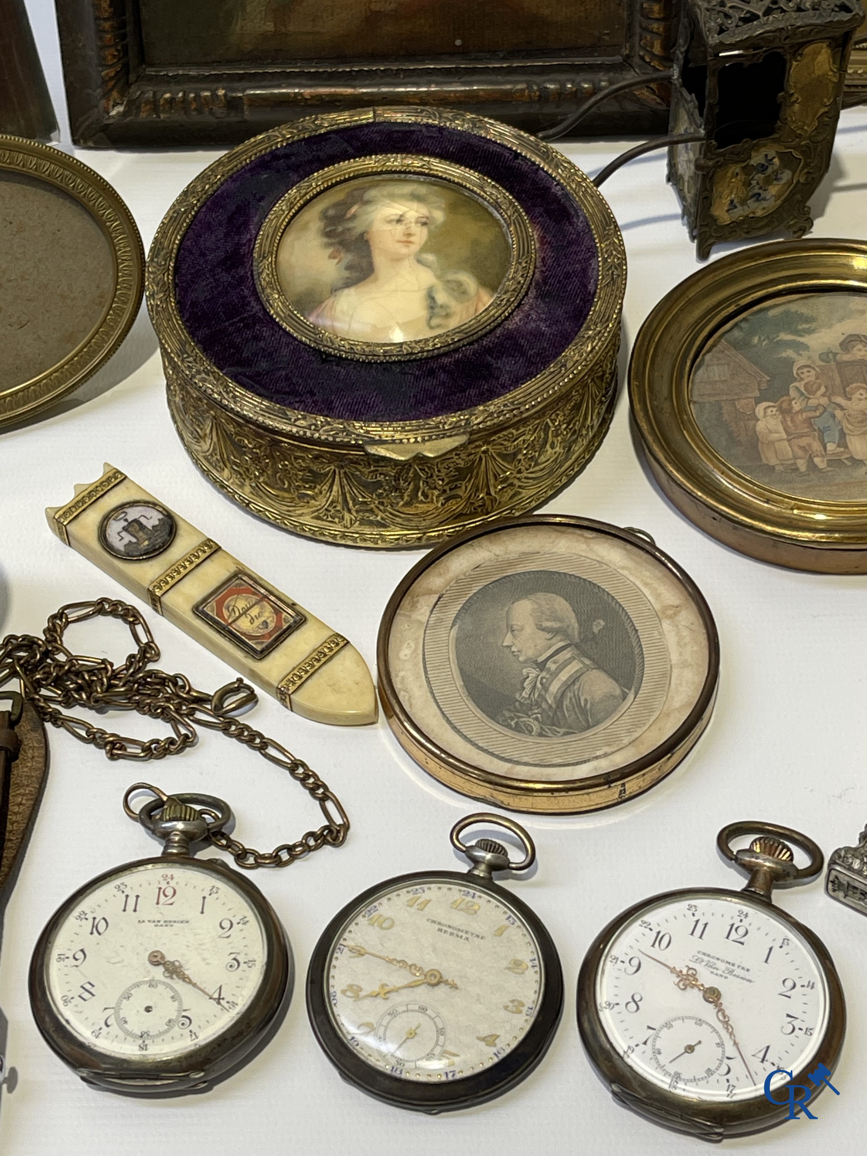 Een uitgebreid lot met vitrineobjecten. Zakhorloges, miniaturen, bronzen kaders, fantasiejuwelen enz. Sommige in zilver.