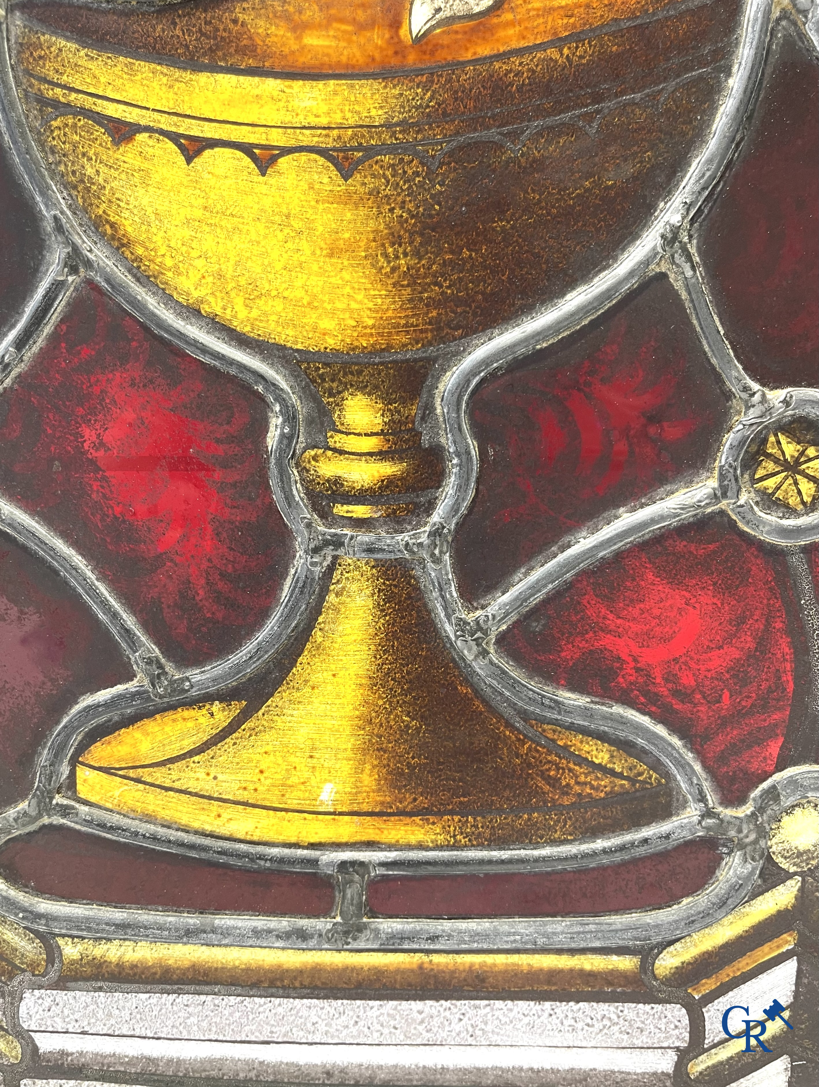 Religieuze objecten. Glas in loodraam met brandglas, kader met kruis in bewerkt leder, ovale kader als souvenir.