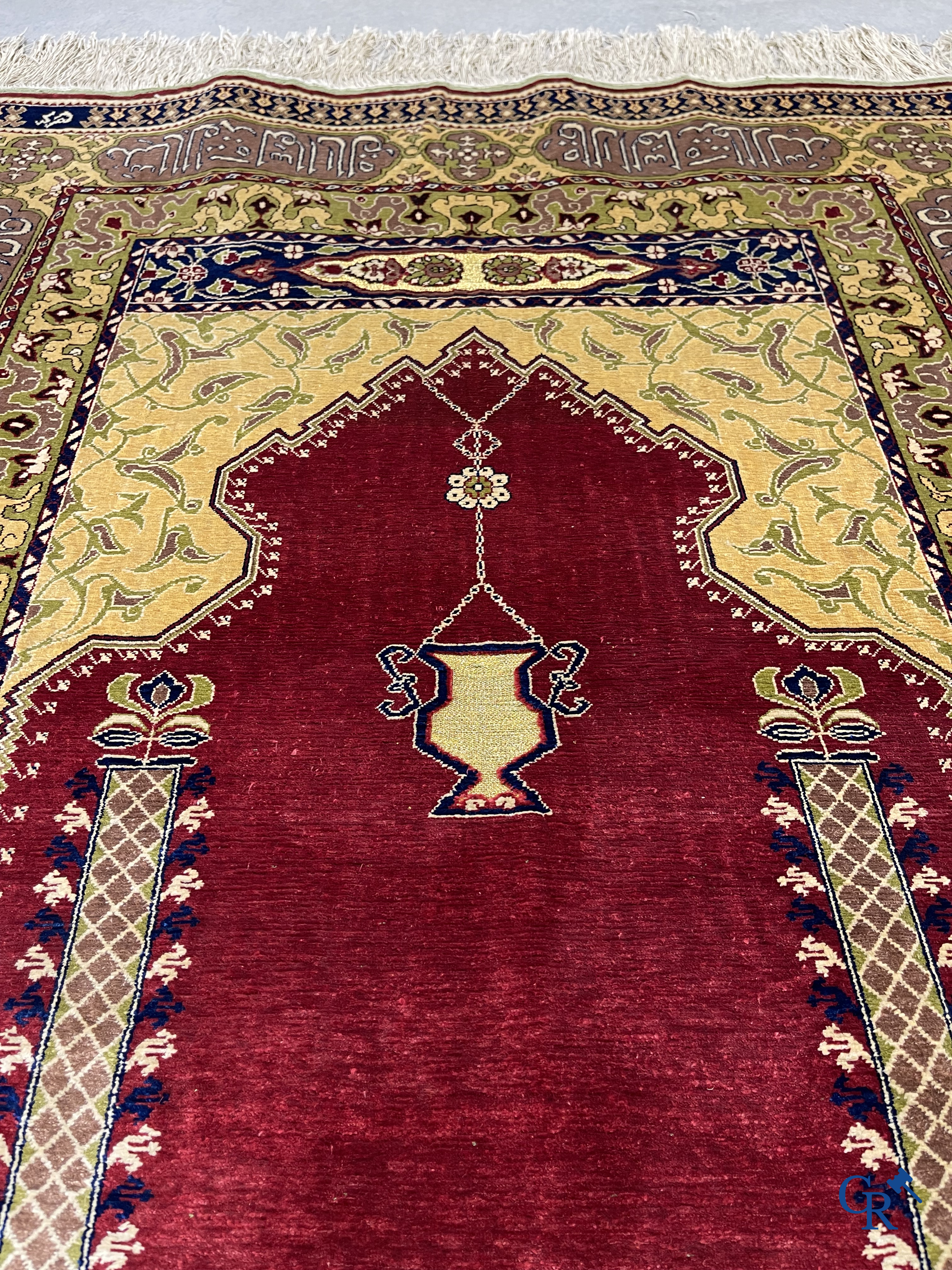 Oosterse tapijten. Een uiterst fijn handgeknoopt zijden tapijt met inscripties en gouddraad. Gesigneerd.