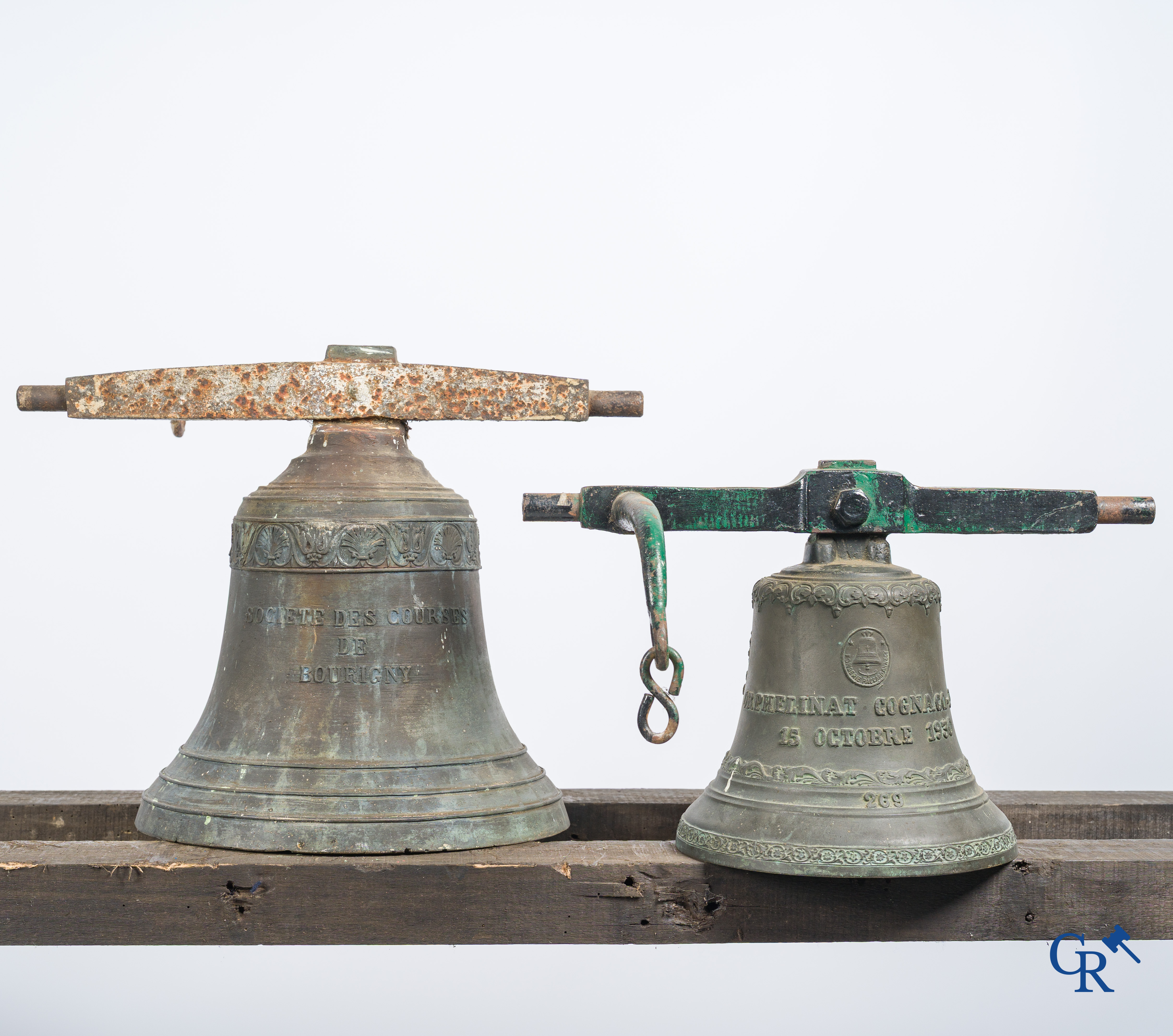 2 Bronzen bellen met smeedijzer juk, waarvan één met een gedecoreerde inscripitieband en afbeelding van een paard.