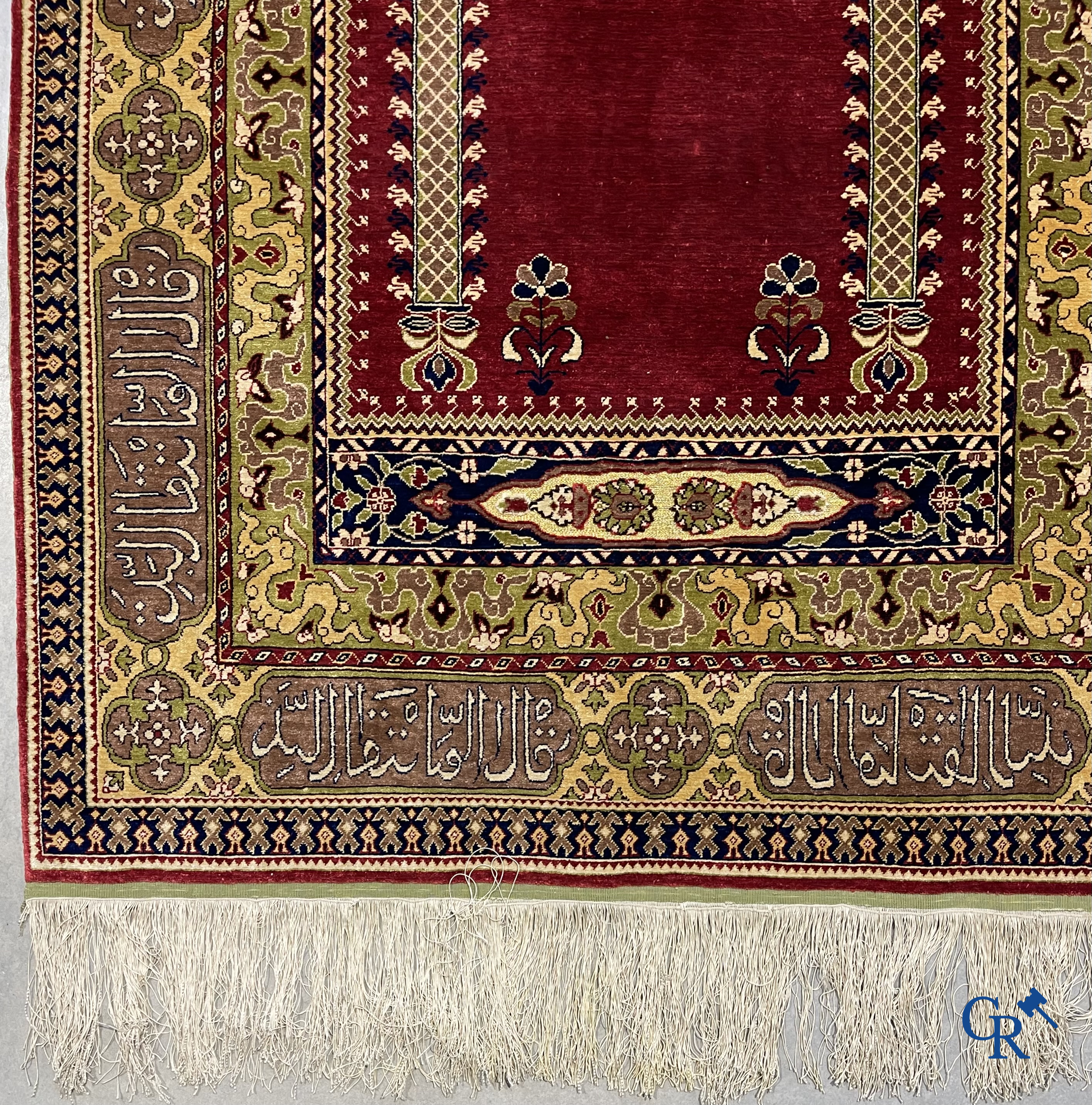 Oosterse tapijten. Een uiterst fijn handgeknoopt zijden tapijt met inscripties en gouddraad. Gesigneerd.