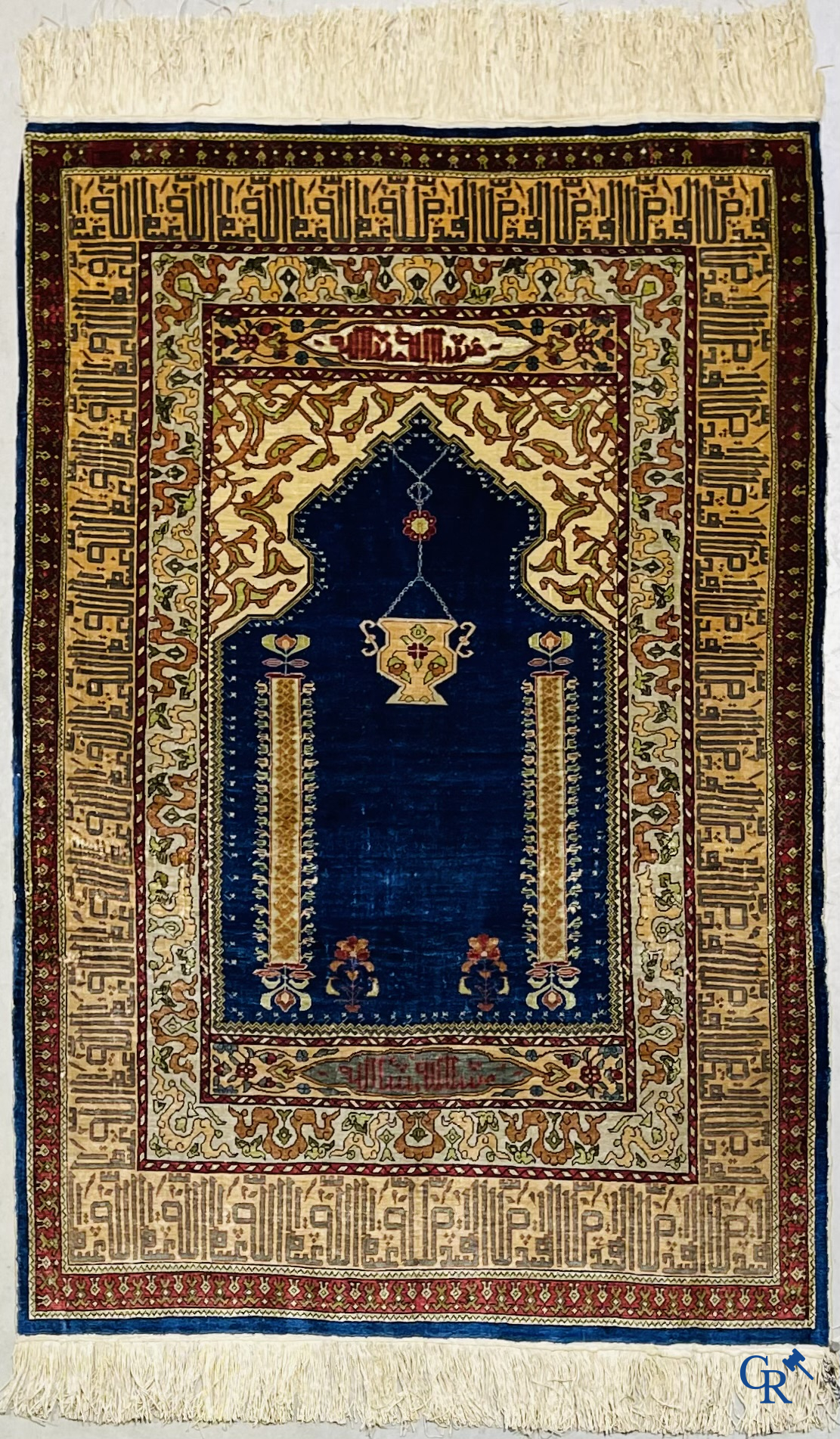 Oosterse tapijten. Een uiterst fijn handgeknoopt zijden tapijt met inscripties en gouddraad. Gesigneerd.