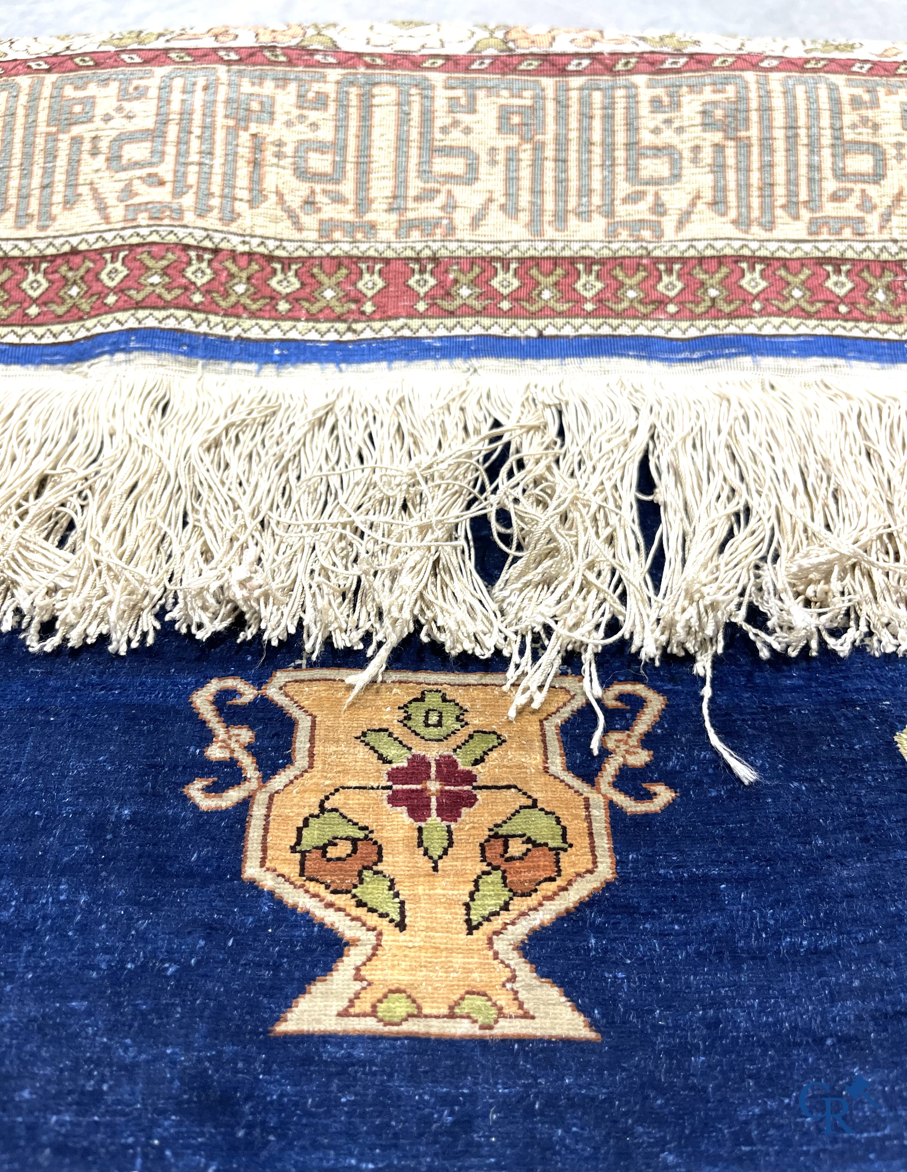 Oosterse tapijten. Een uiterst fijn handgeknoopt zijden tapijt met inscripties en gouddraad. Gesigneerd.