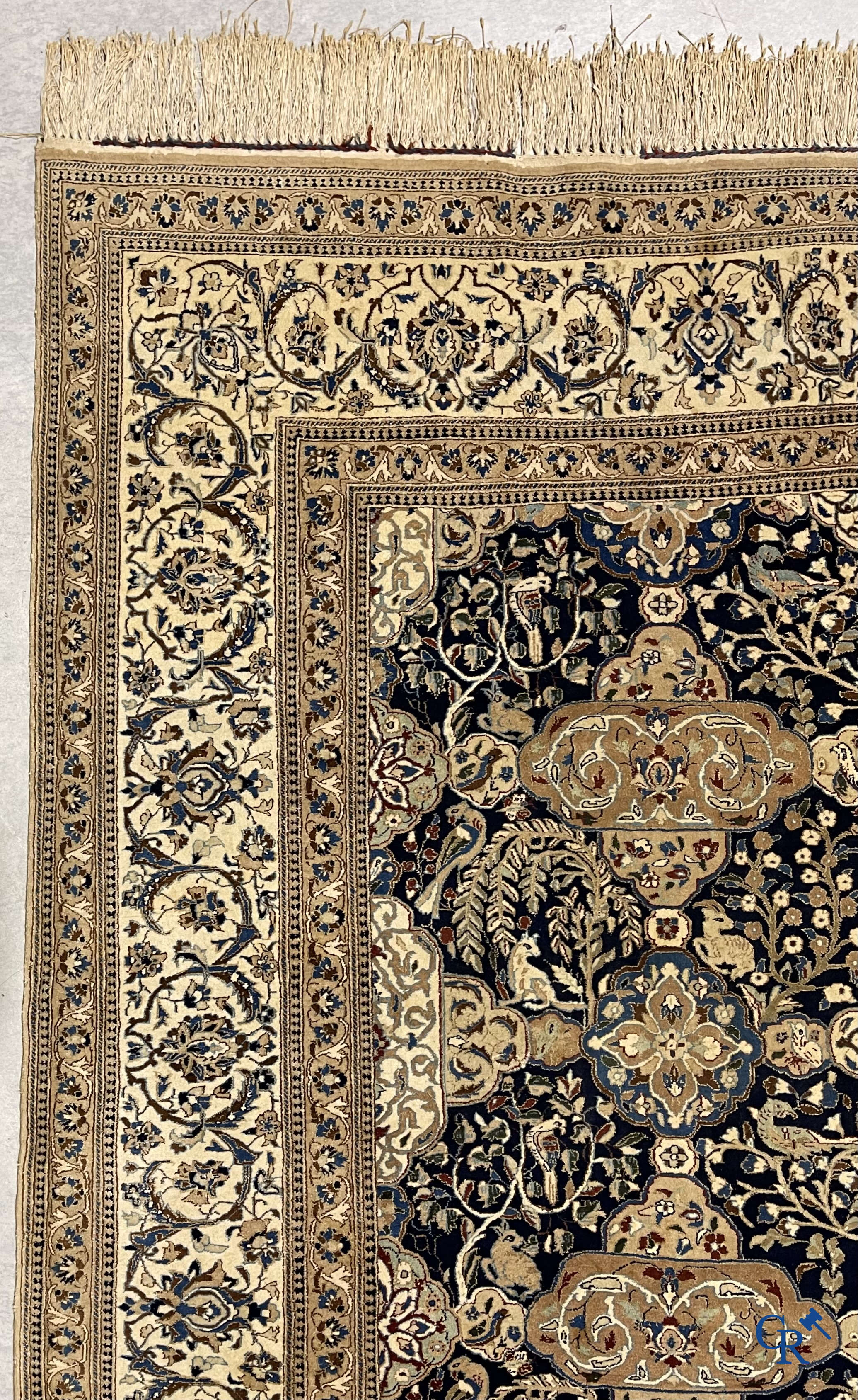 Oosterse tapijten. Een handgeknoopt tapijt met wouddieren en bloemen.