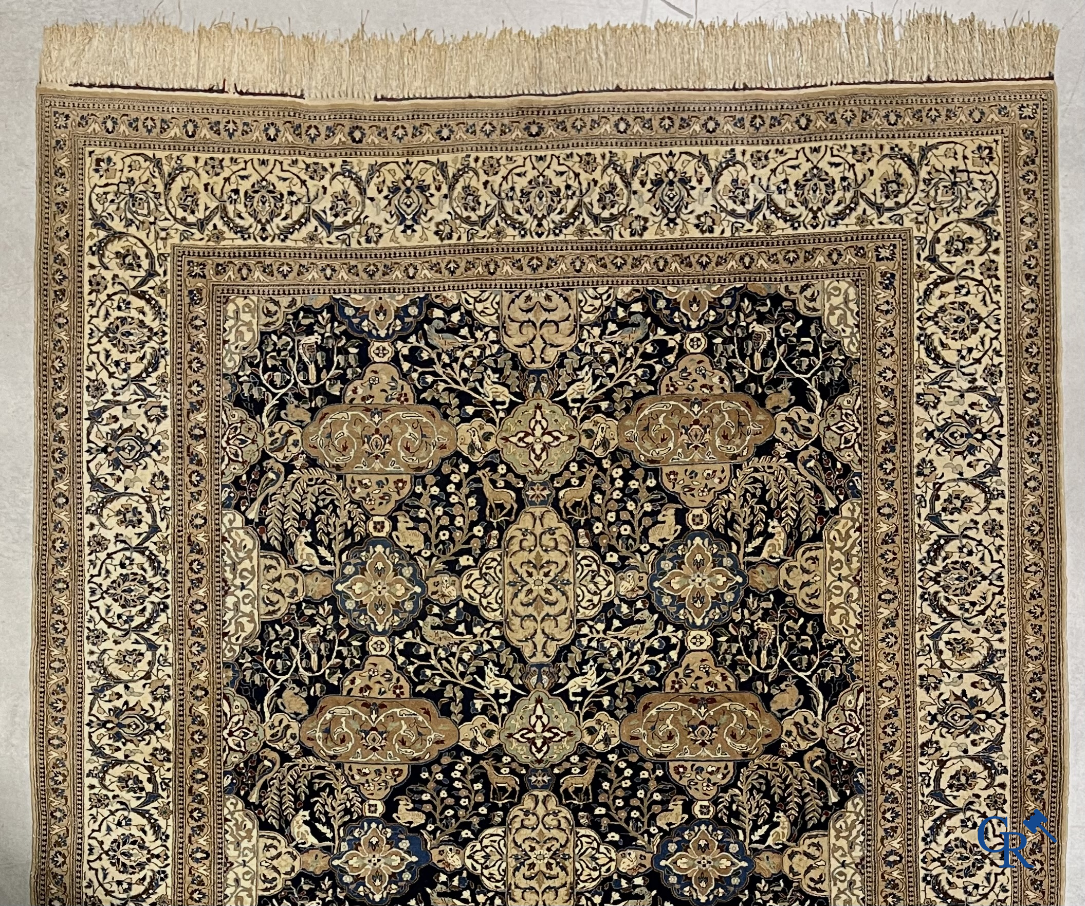 Oosterse tapijten. Een handgeknoopt tapijt met wouddieren en bloemen.