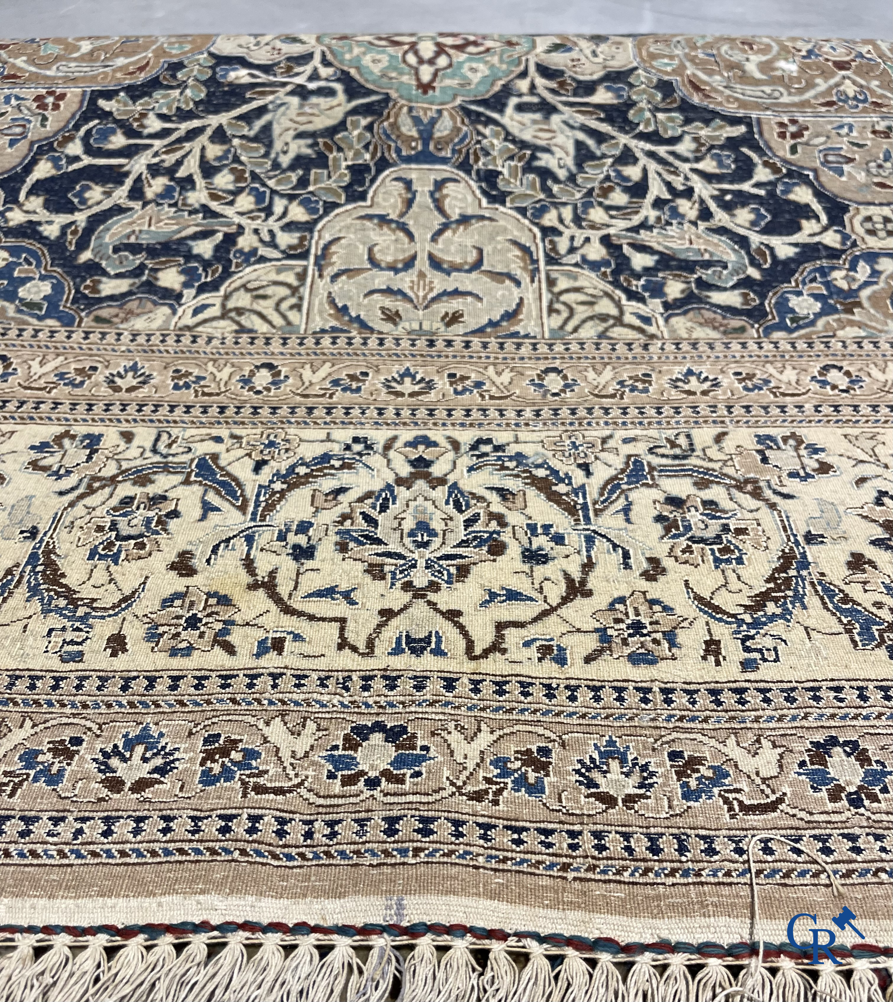 Oosterse tapijten. Een handgeknoopt tapijt met wouddieren en bloemen.